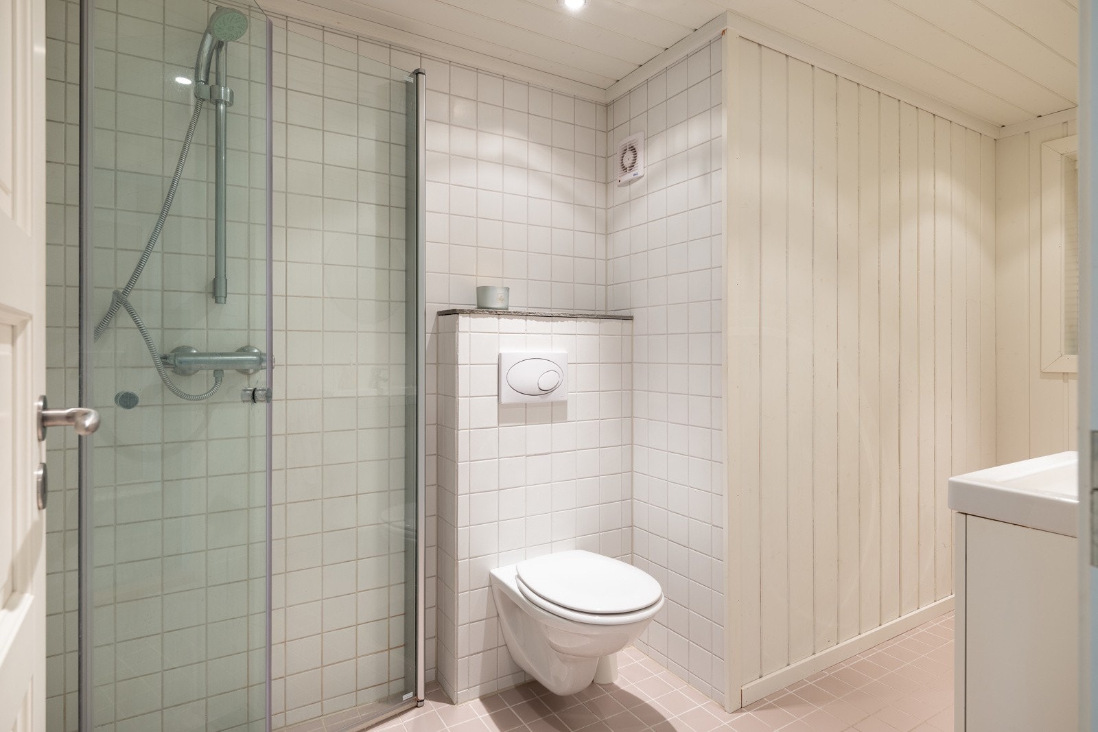 Badet har flislagt gulv med varmekabler, fliser i dusjsone, samt panel på vegger. Galleribilde