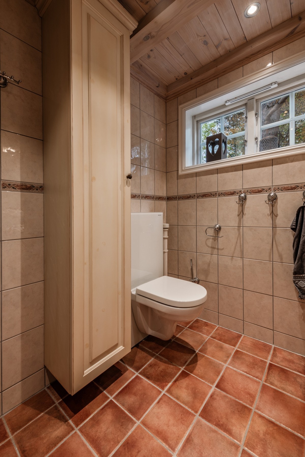 Badet har flislagte vegger og gulv Galleribilde