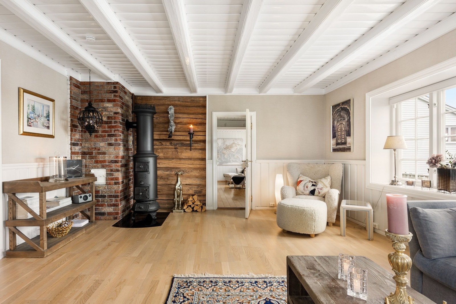 Stuen har fine detaljer som takbjelker og tømmervegg. Nydelig etasjeovn. Galleribilde