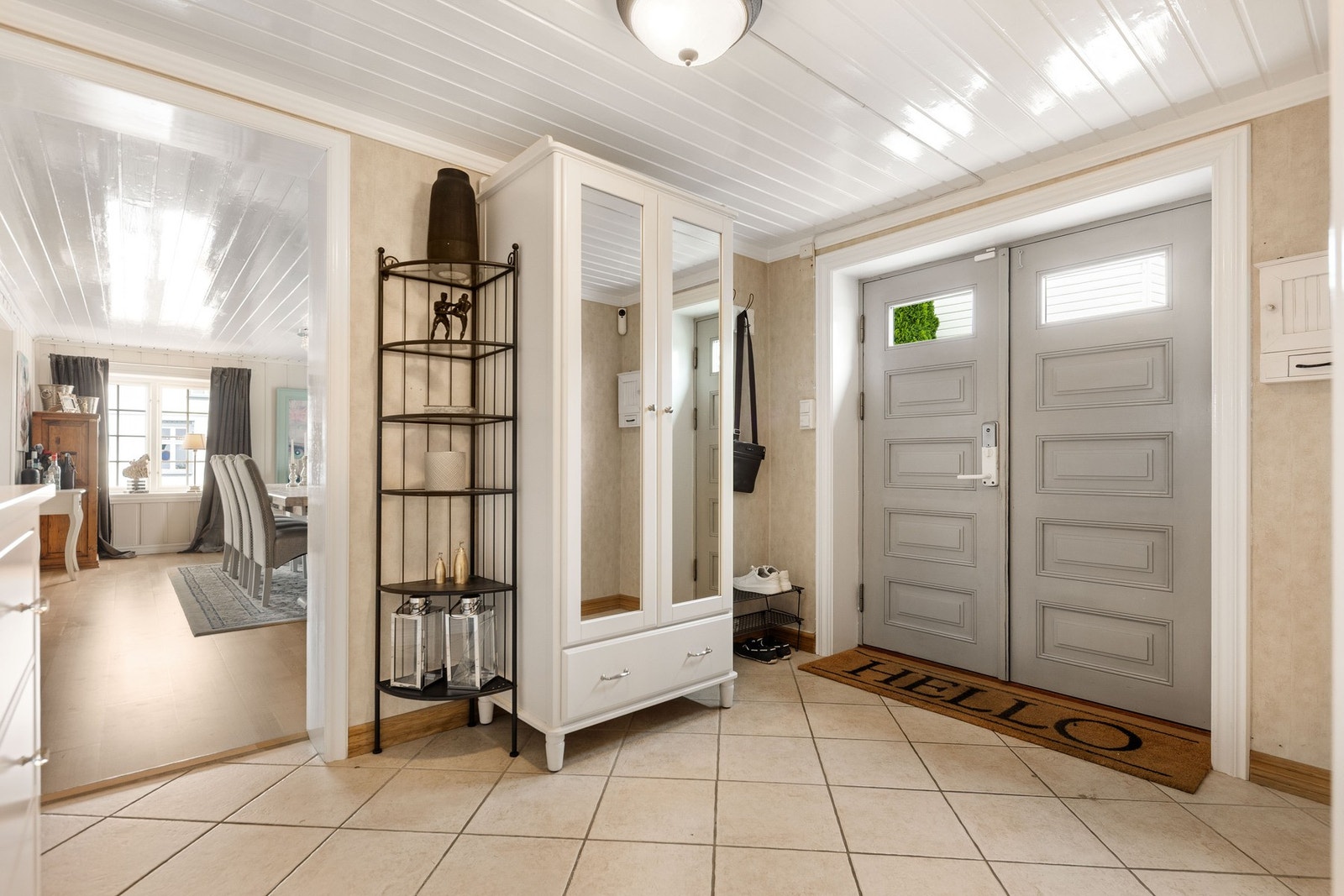 Lyst og romslig inngangsparti med flislagt gulv og god oppbevaringsplass. Galleribilde