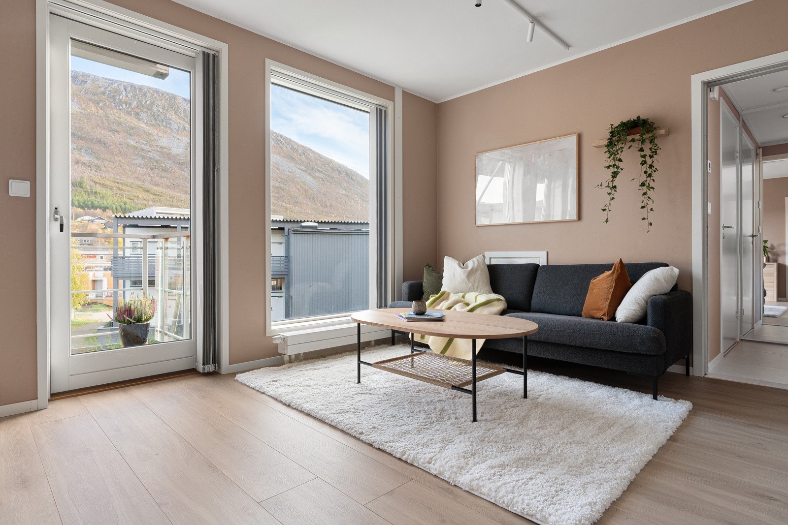 Stuen har plass for både sofa og spisebord. Store vindusflater som slipper inn rikelige mengder med naturlig lys.