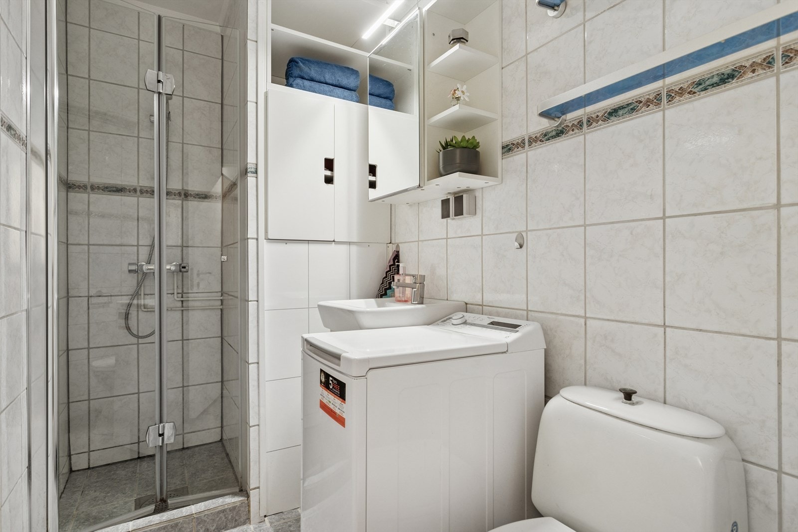 Badet har innredning med nedfelt servant, gulvmontert toalett og røropplegg for vaskemaskin. Galleribilde