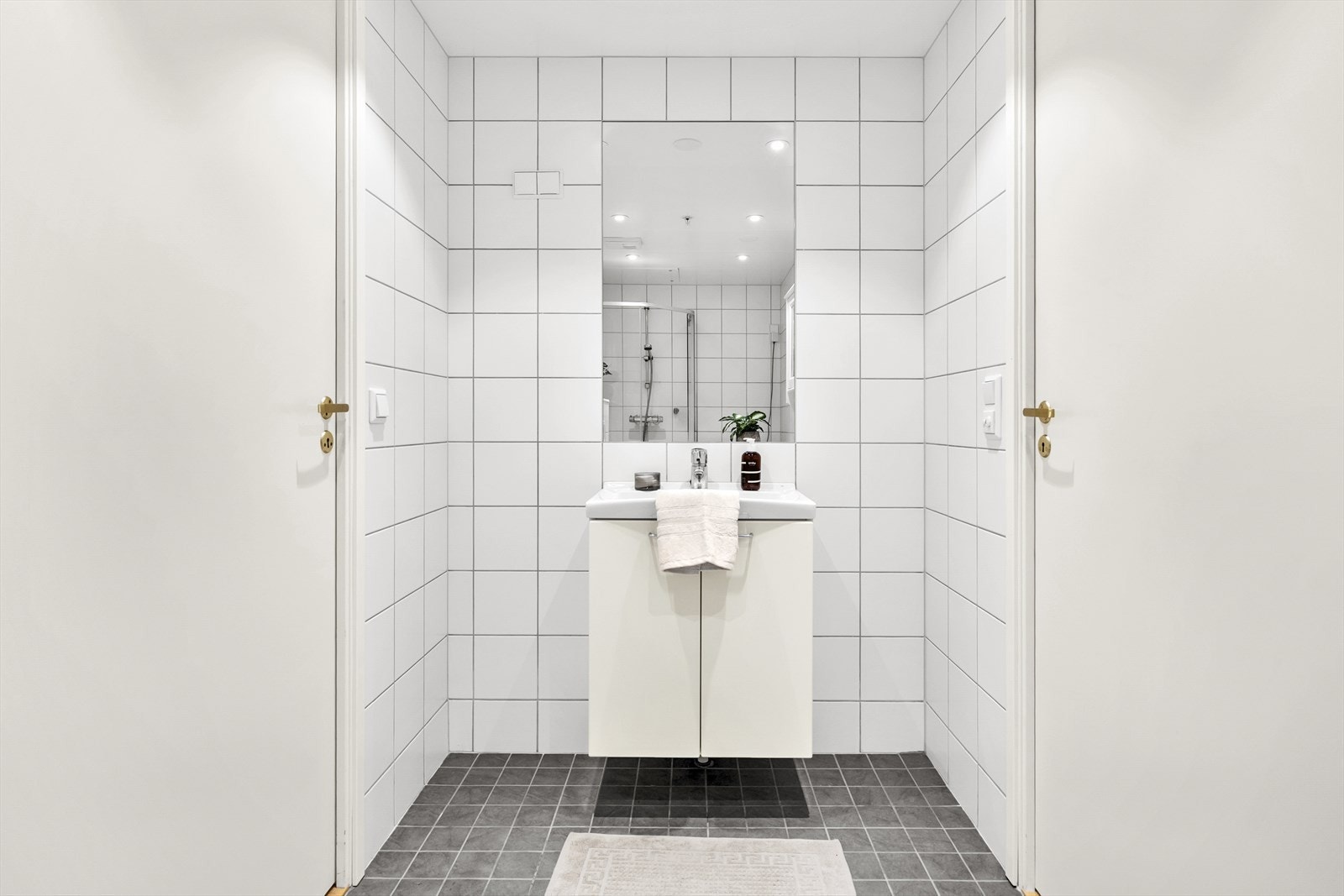 Badet er innredet med servant i baderomsmøbel, dusjhjørne og vegghengt toalett. Det er opplegg for vaskemaskin. Galleribilde