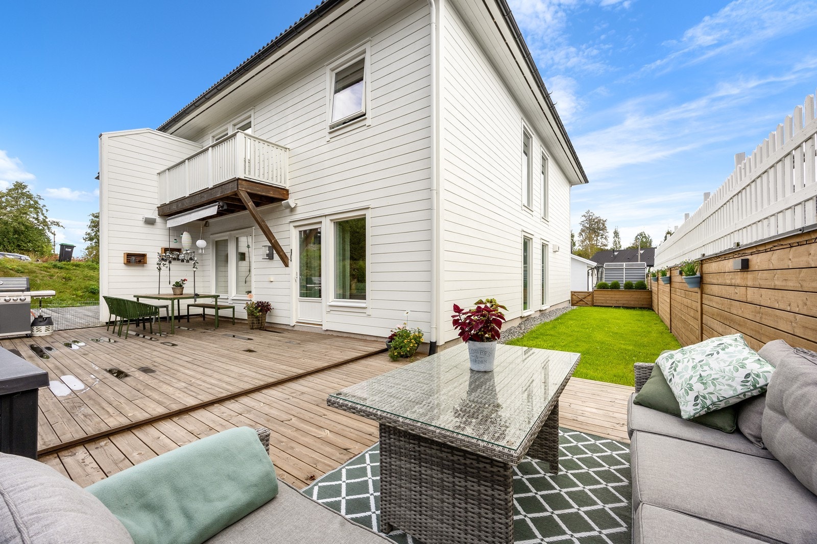 Hagen er inngjerdet, opparbeidet med en flat gressplen og en blomsterkasse mot gårdsplassen. Galleribilde