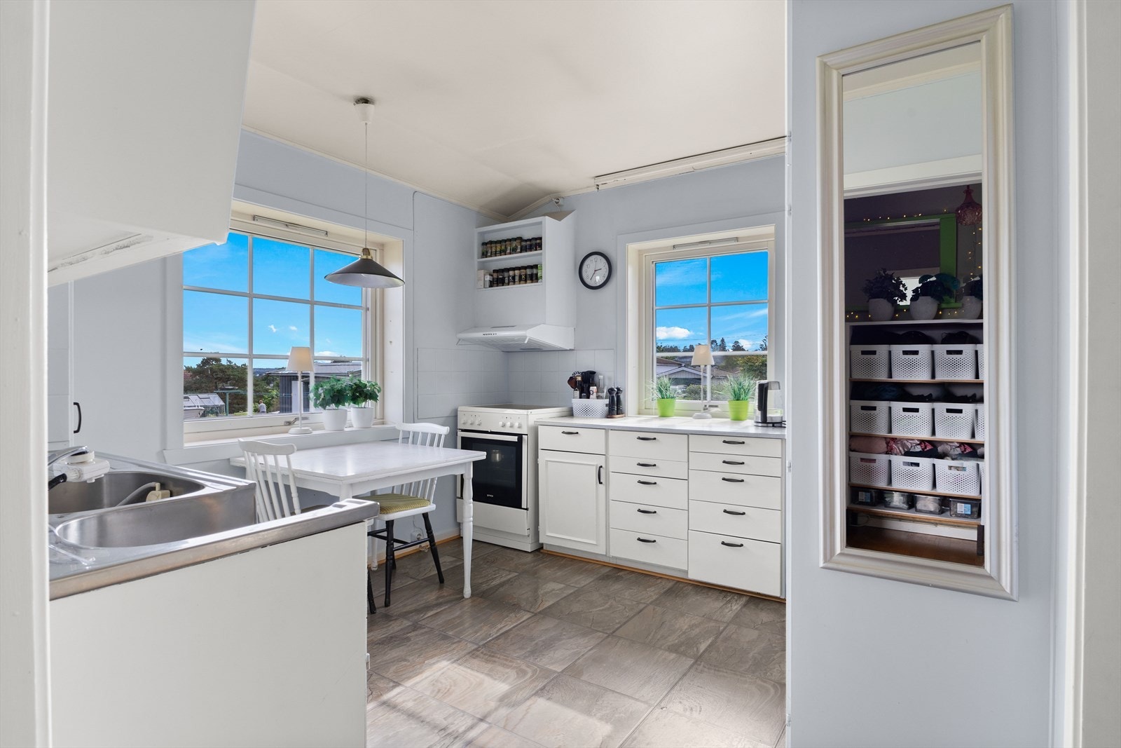 Kjøkkenet har lyse profilerte fronter, laminert benkeplate og fliser mellom benk og overskap. Her er det opplegg for alle nødvendige hvitevarer, og ventilator med avtrekk ut sikrer effektiv lufting. Galleribilde