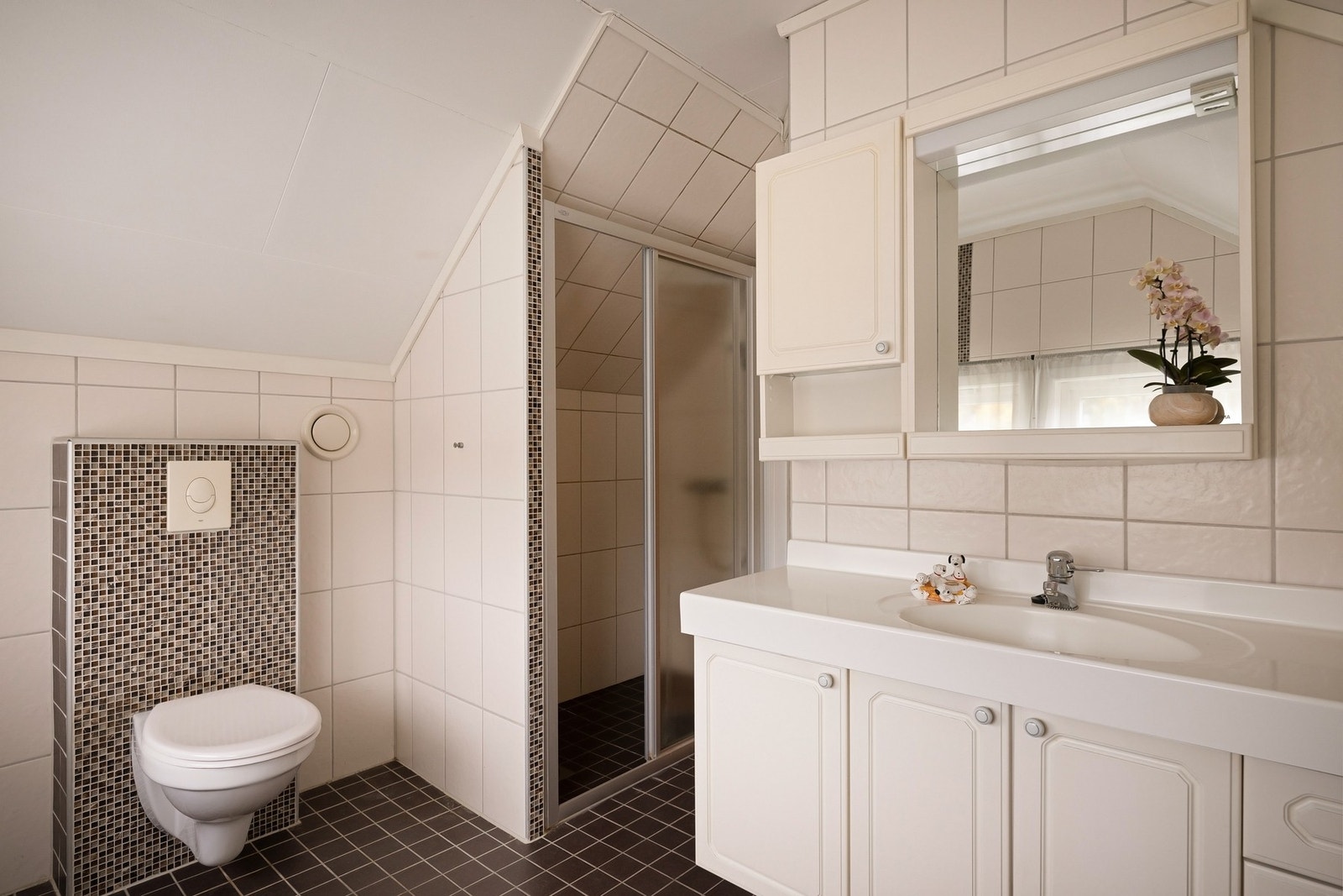 Bad med vegghengt wc og dusj i nisje med dører Galleribilde