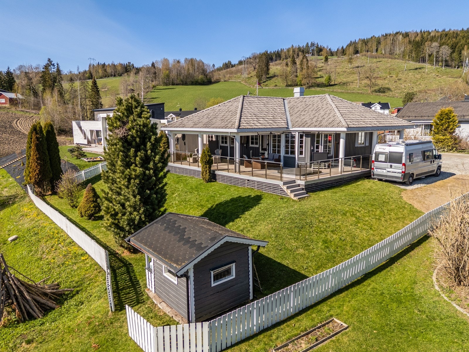 Eiendommen er innrammet av et pent stakittgjerde. Gruset gårdsplass med muligheter for biloppstilling. Galleribilde