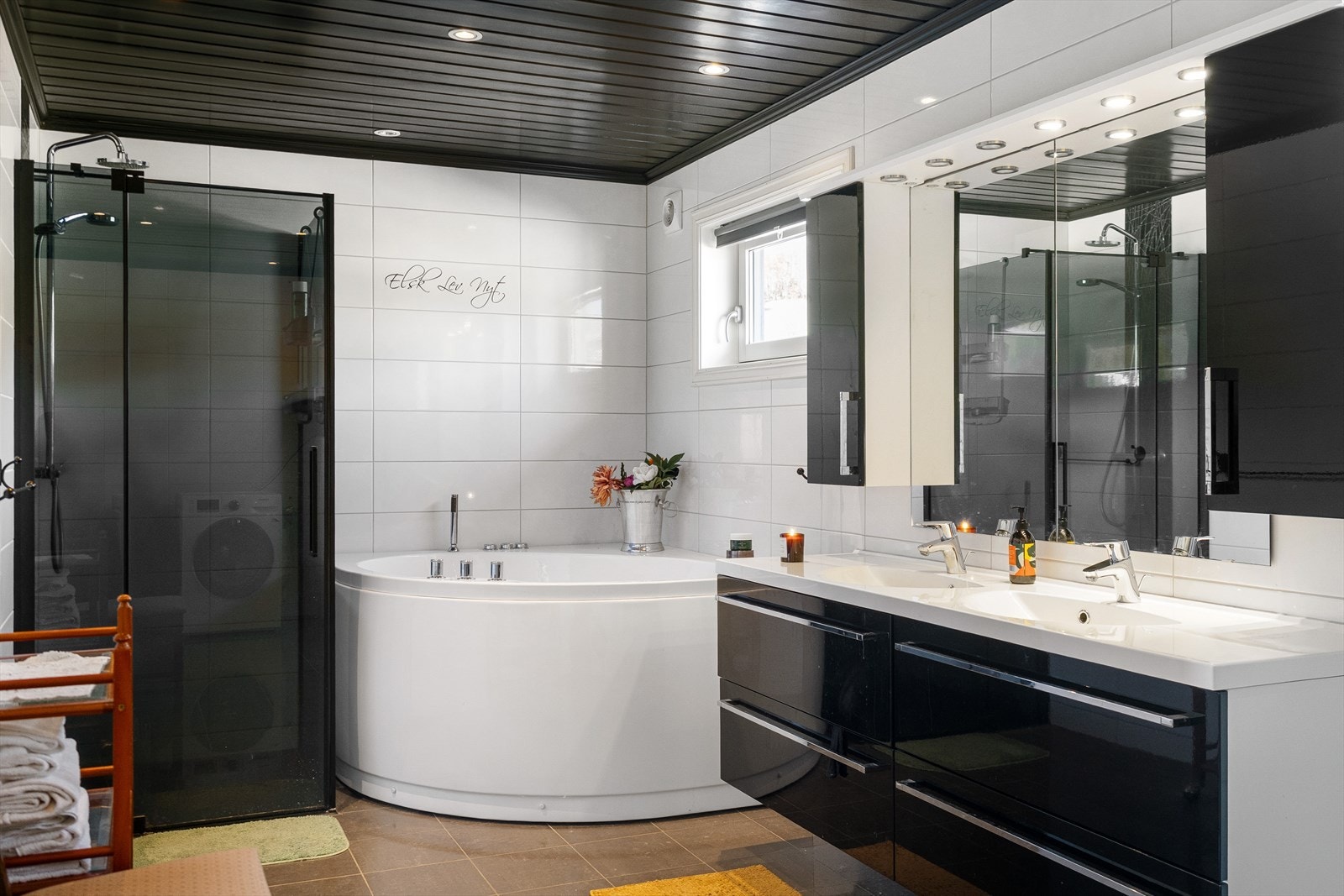 Badet er innredet med servantskap med dobbel servant, vegghengt toalett, opplegg for vaskemaskin, vegghengt dusj med dusjnisje i glass/metall samt boblebadekar. Galleribilde