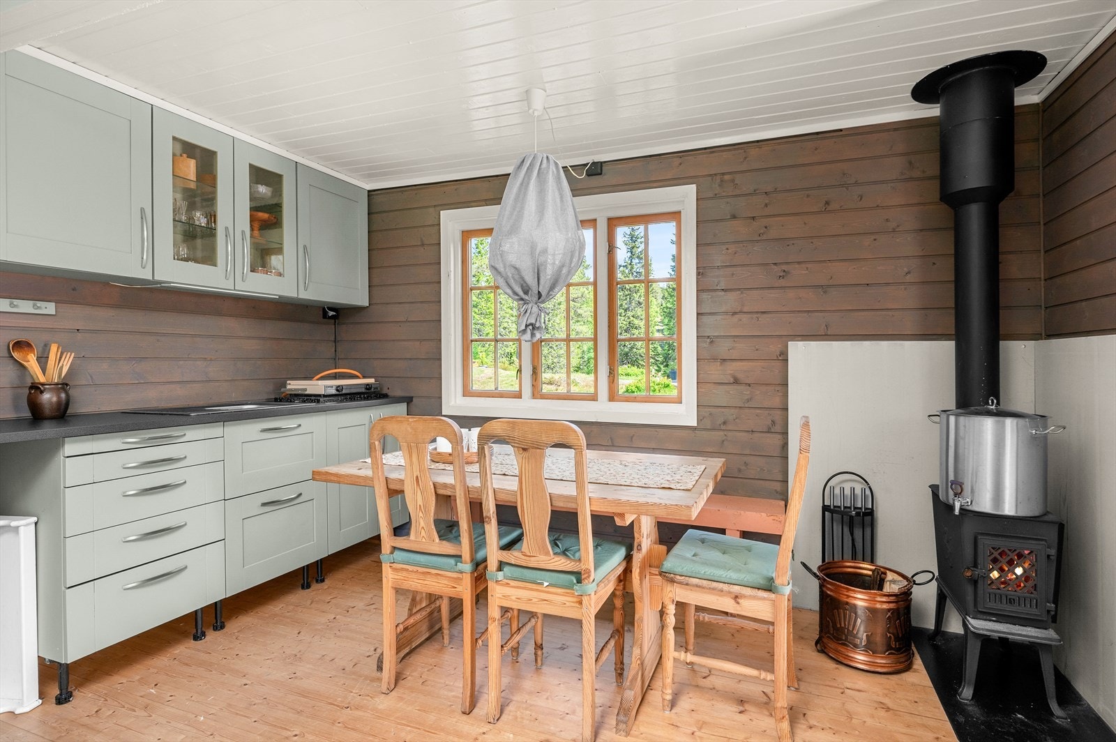 Videre inn i annekse har man eget kjøkken, spisebord og vedovn. Galleribilde