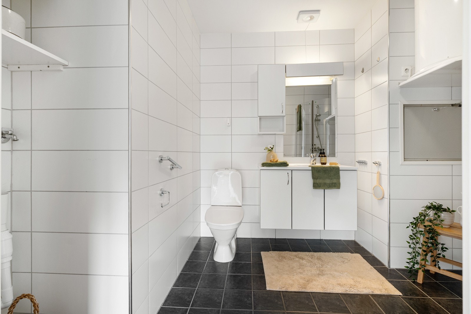 Badet har elektriske varmekabler og er innredet med nedfelt servant, toalett, dusjhjørne, elektrisk styrt vifte og opplegg for vaskemaskin. Galleribilde