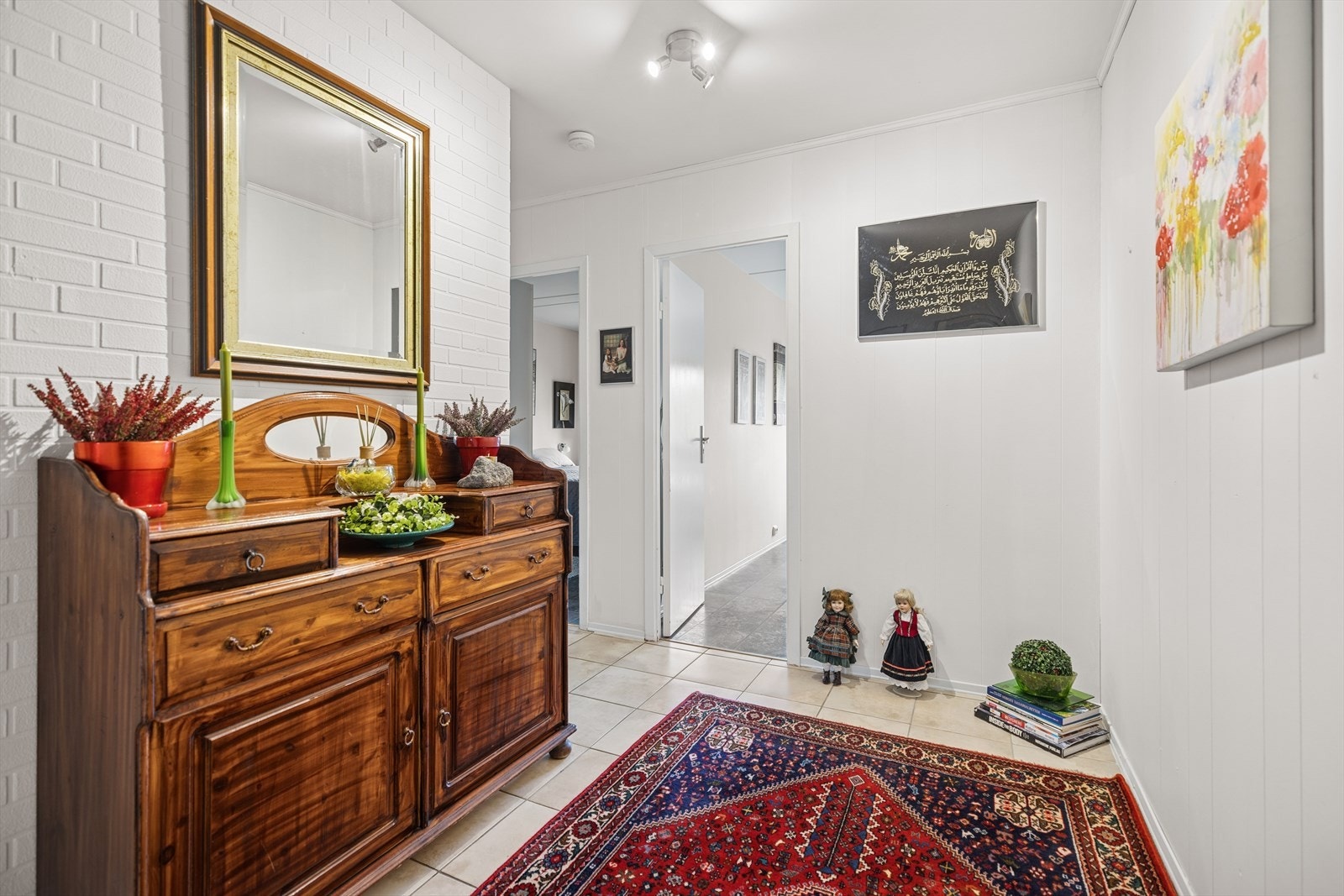 Entréen fremstår lys og velholdt med klassisk stil og tidløse materialer. Plass til kommode og dekor som skaper et varmt og hyggelig preg ved inngangen. Galleribilde