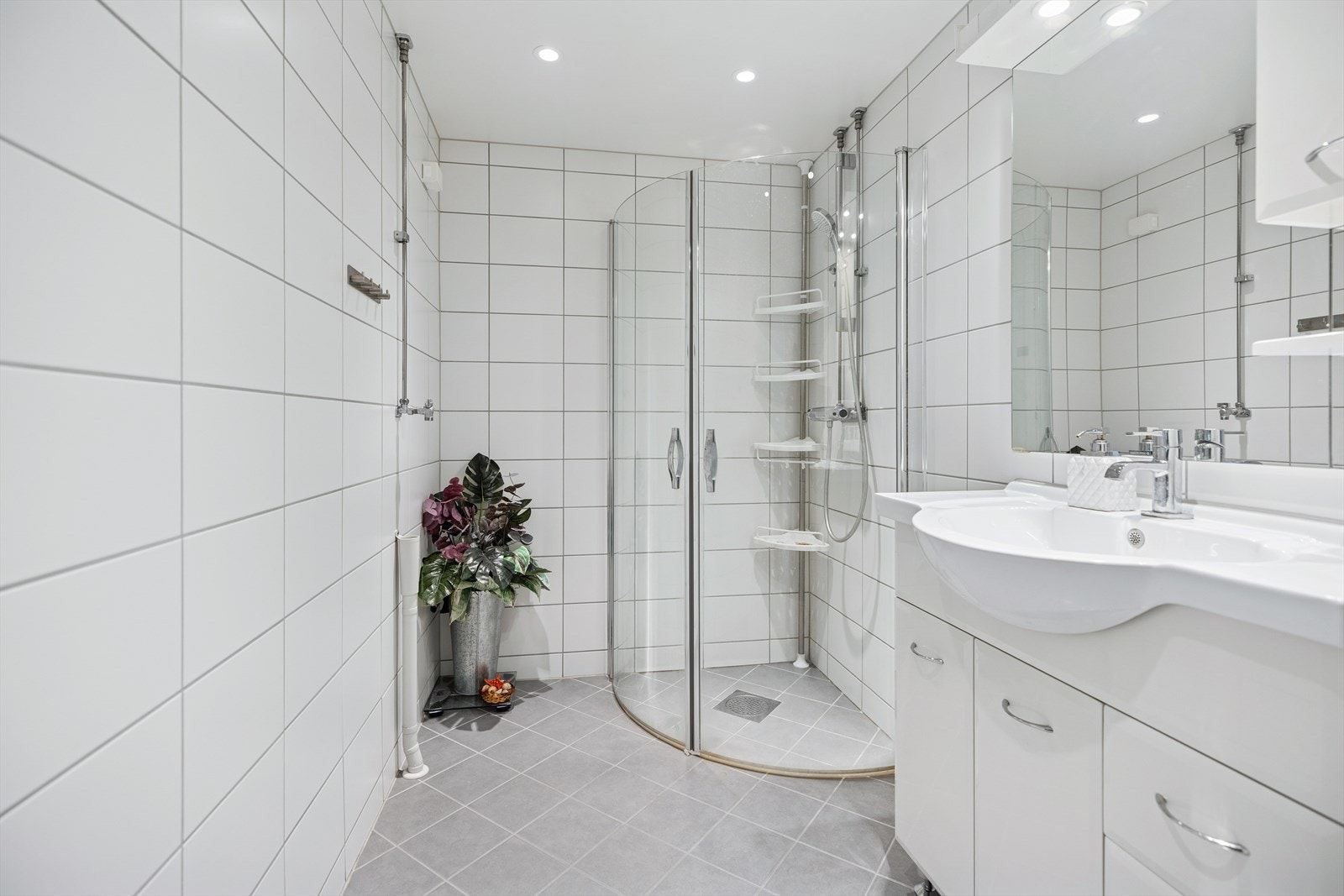 Stilrent og flislagt bad fra 2021 med dusjhjørne, servantinnredning og praktisk oppbevaringsplass. Badet har gulvvarme som sørger for behagelig varme året rundt. Galleribilde