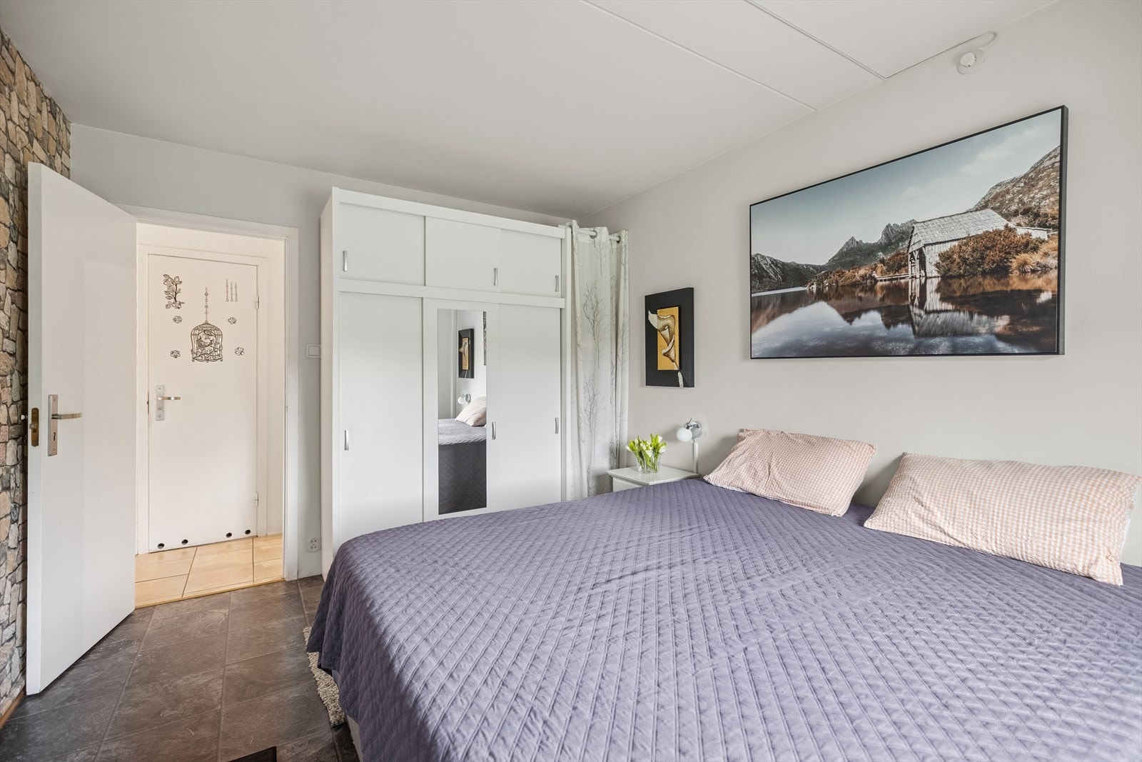 Rommet har praktisk garderobeløsning med speilfronter og god oppbevaringsplass, som bidrar til en ryddig og helhetlig stil. Galleribilde
