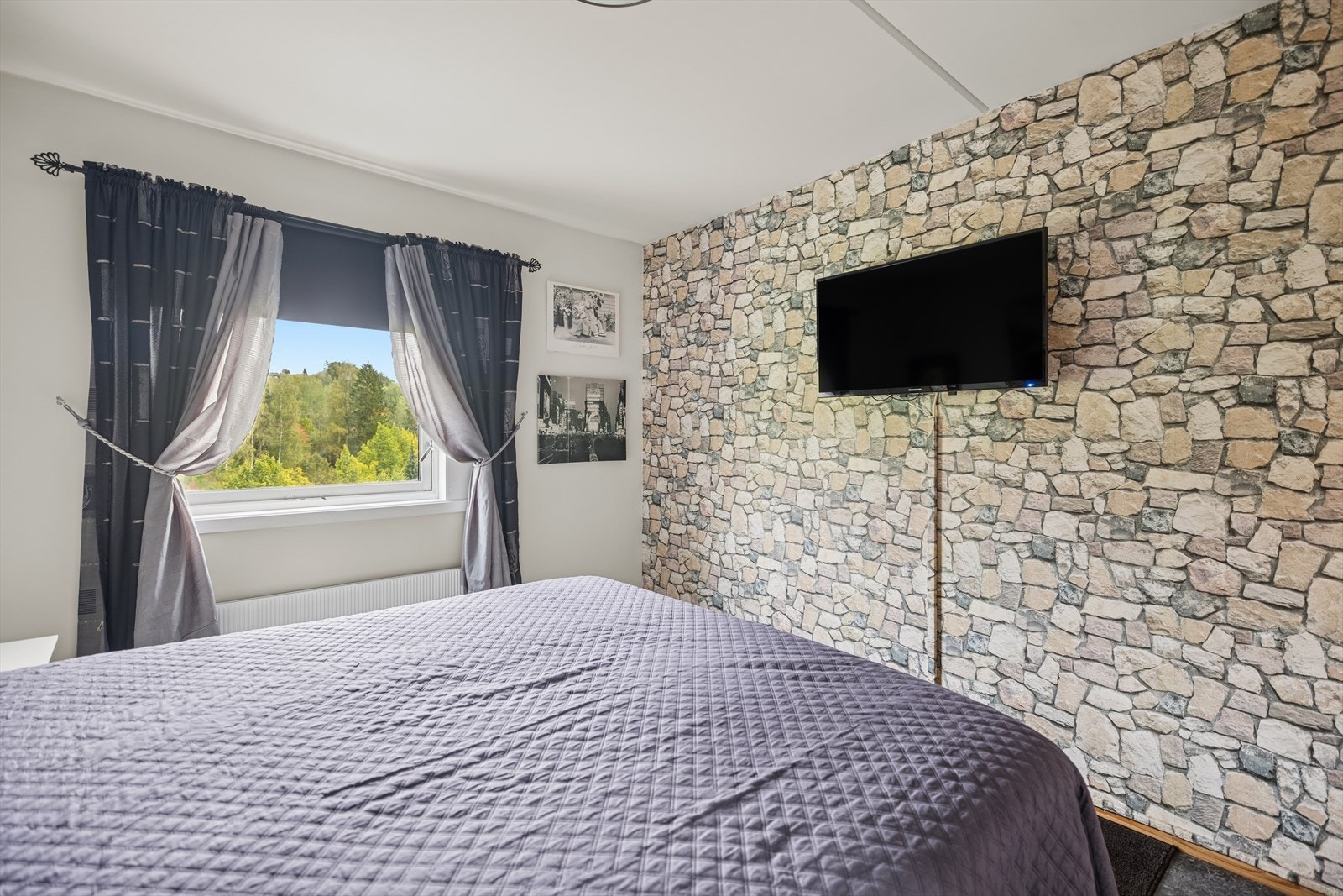 Vinduer som slipper inn rikelig med naturlig lys og gir utsyn mot grønne omgivelser - kombinert med en moderne fondvegg som skaper karakter. Galleribilde