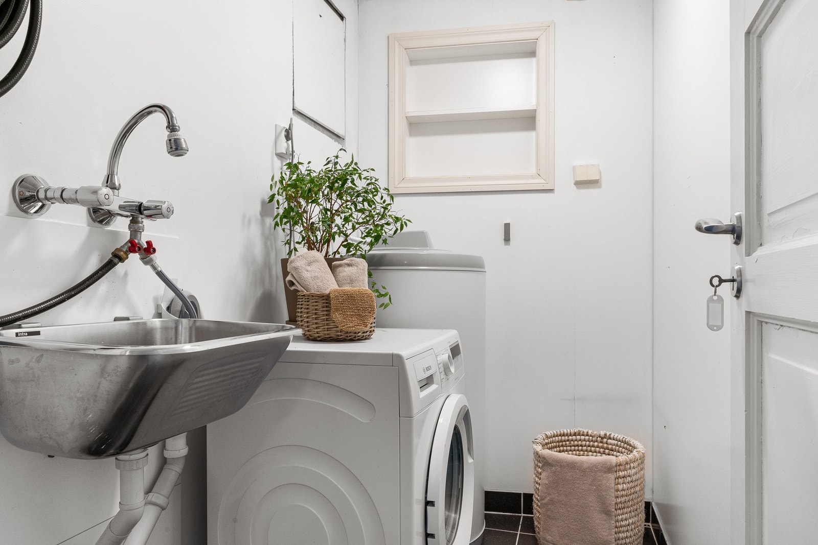 Vaskerommet har fliselagt gulv med varmekabler. Her er vvb., utslagsvask og fordelerskap for rør i rør-system plassert. Galleribilde