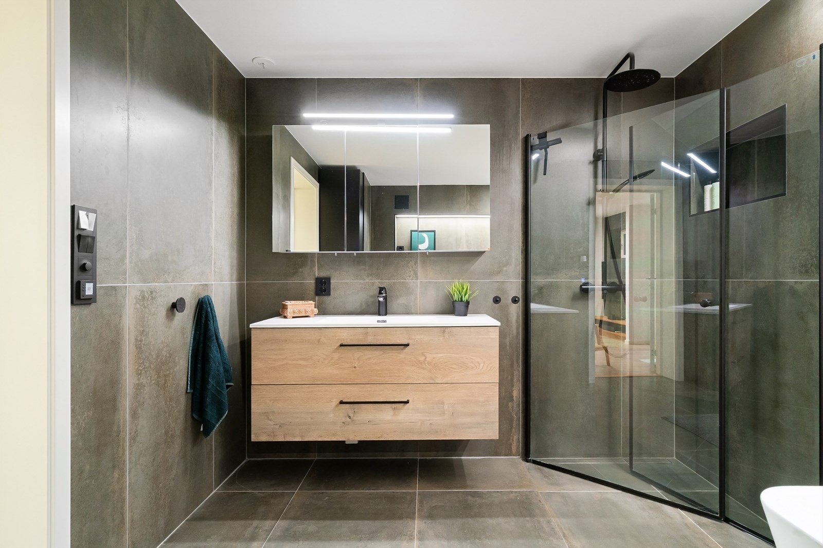 Bad i underetasje fra 2021 med regnfallsdusj, veggmontert wc, servant og badekar Galleribilde