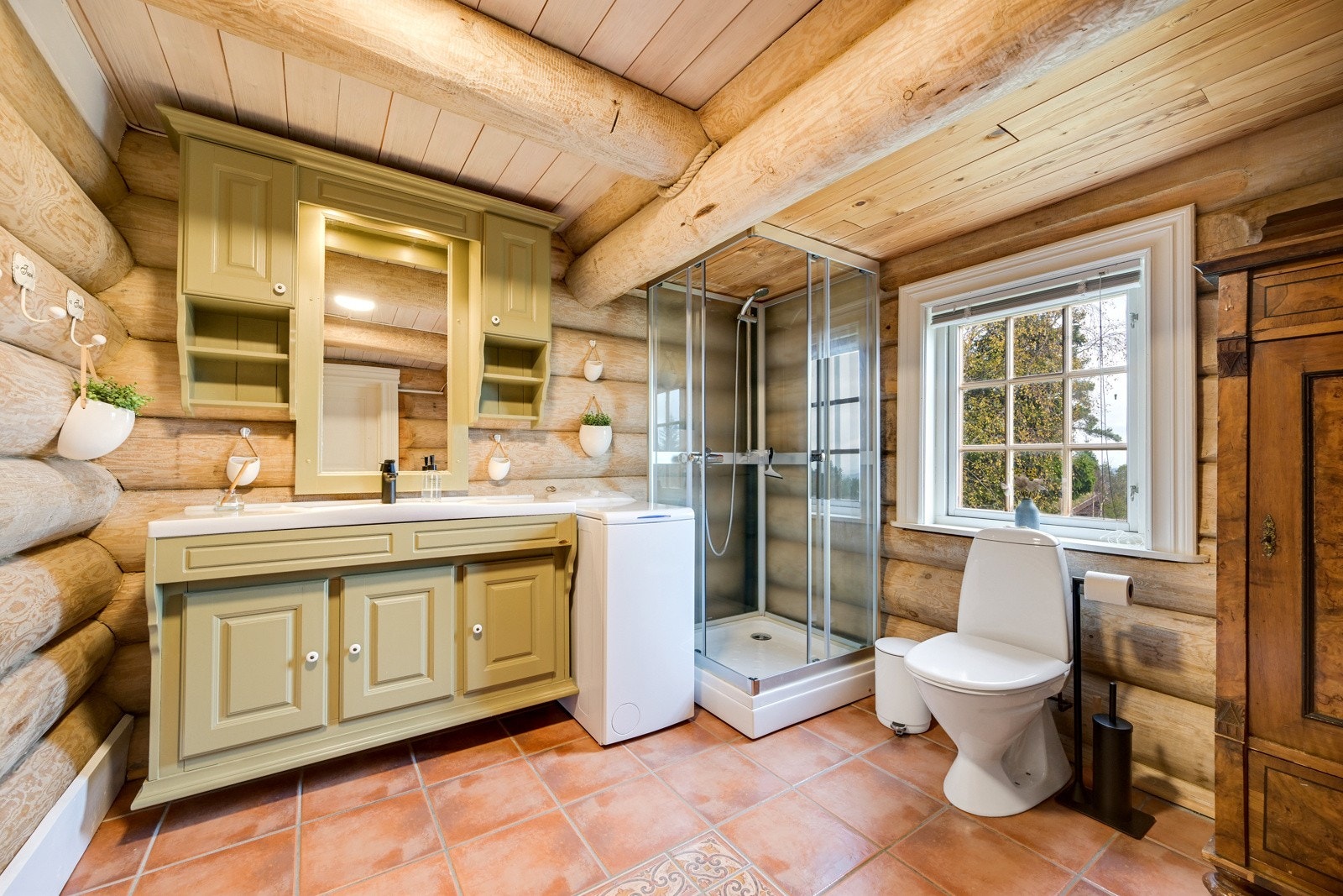 Pent flislagt bad med servant, dusjkabinett og gulvstående toalett. Galleribilde