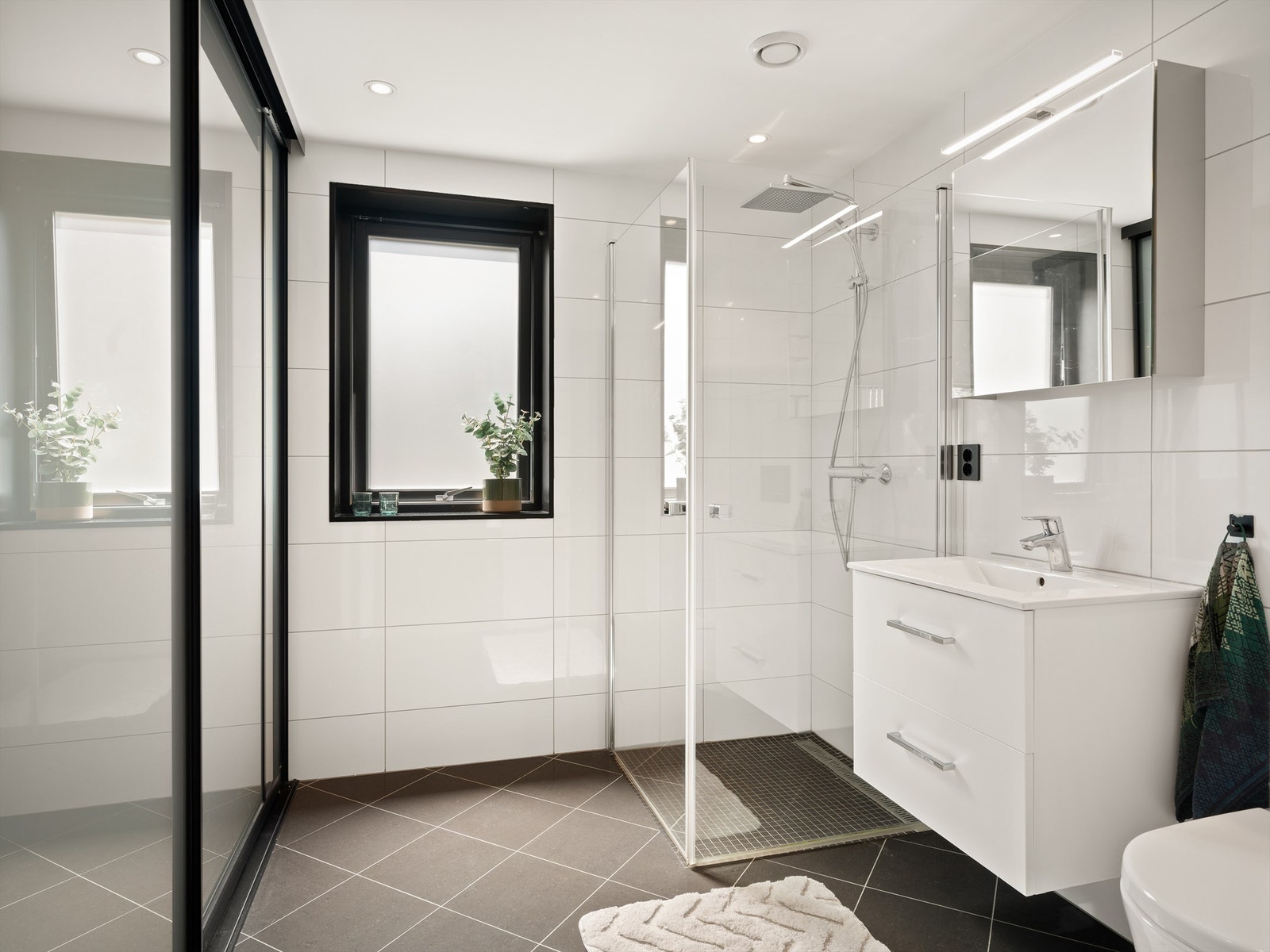 Lekre bad i begge etasjer er blant boligens fremste kvaliteter. Bak skyvedørene er det plass til både vaskemaskin og tørketrommel. Galleribilde