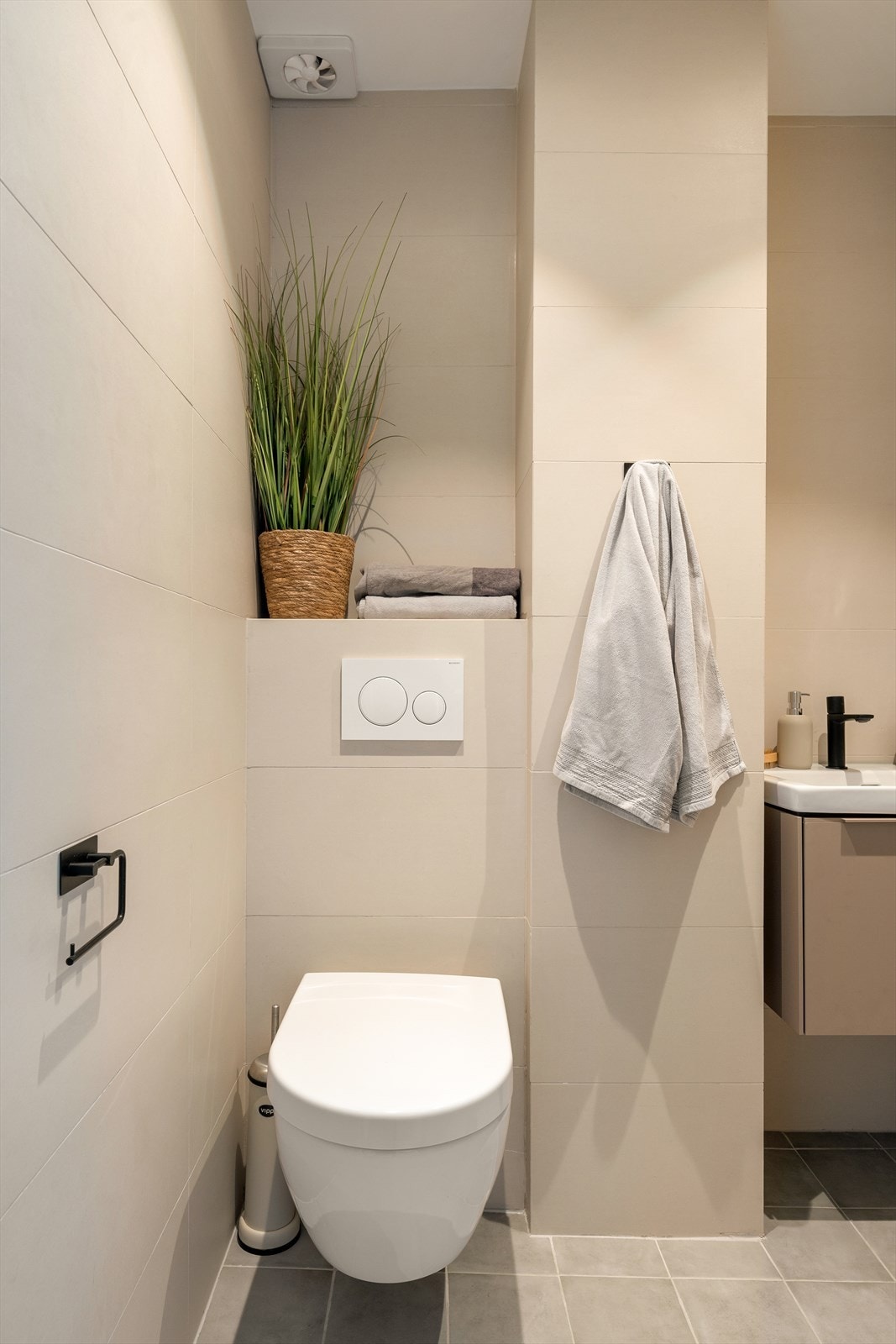 Badet består av vegghengt tolaett, servant med underskap og dusj. Galleribilde