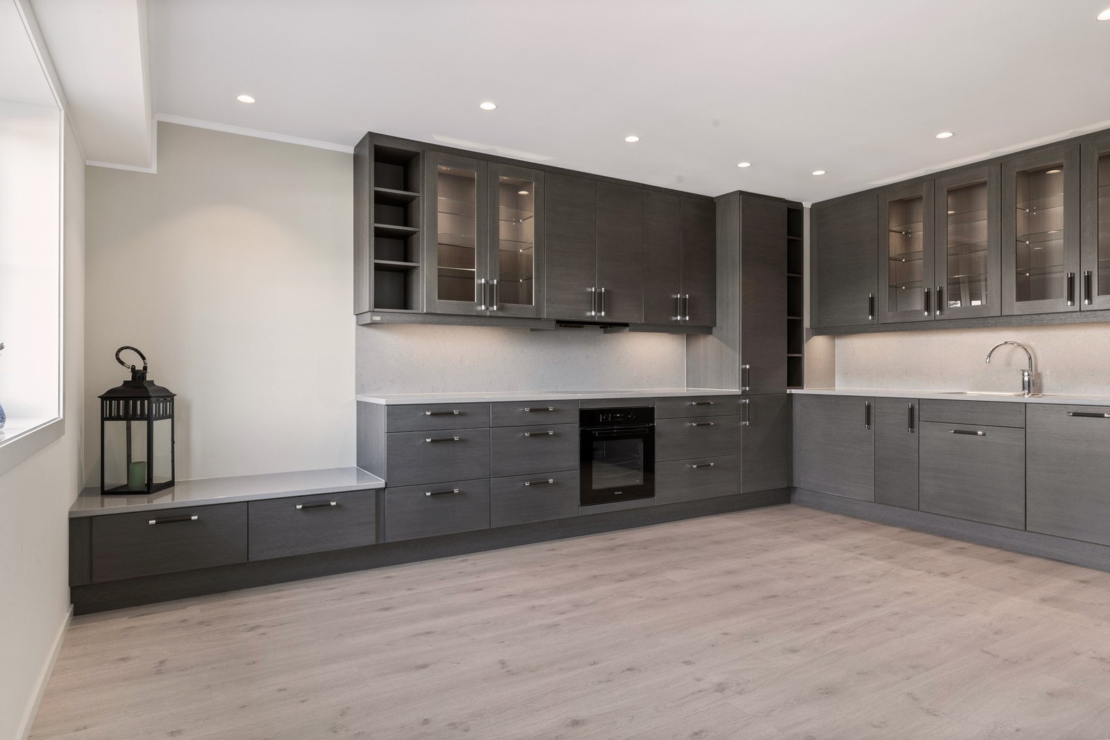 Kjøkkenet er påkostet Huseby innredning med integrerte hvitevarer fra Miele og stilfull benkeplate i kompositt Galleribilde