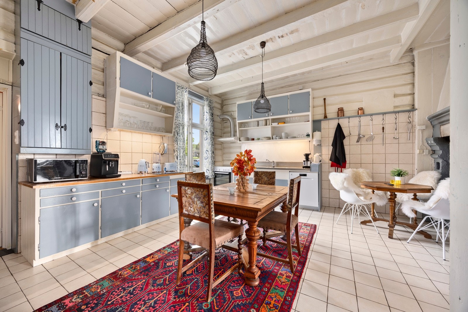 Kjøkkenet har en eldre, plassbygd innredning med glatte fronter og benkeplate i heltre, som gir et solid og rustikt uttrykk. Det er utstyrt med kjøleskap, oppvaskmaskin og komfyr. I tillegg finnes en tradisjonell grue som gir karakter til rommet. Galleribilde