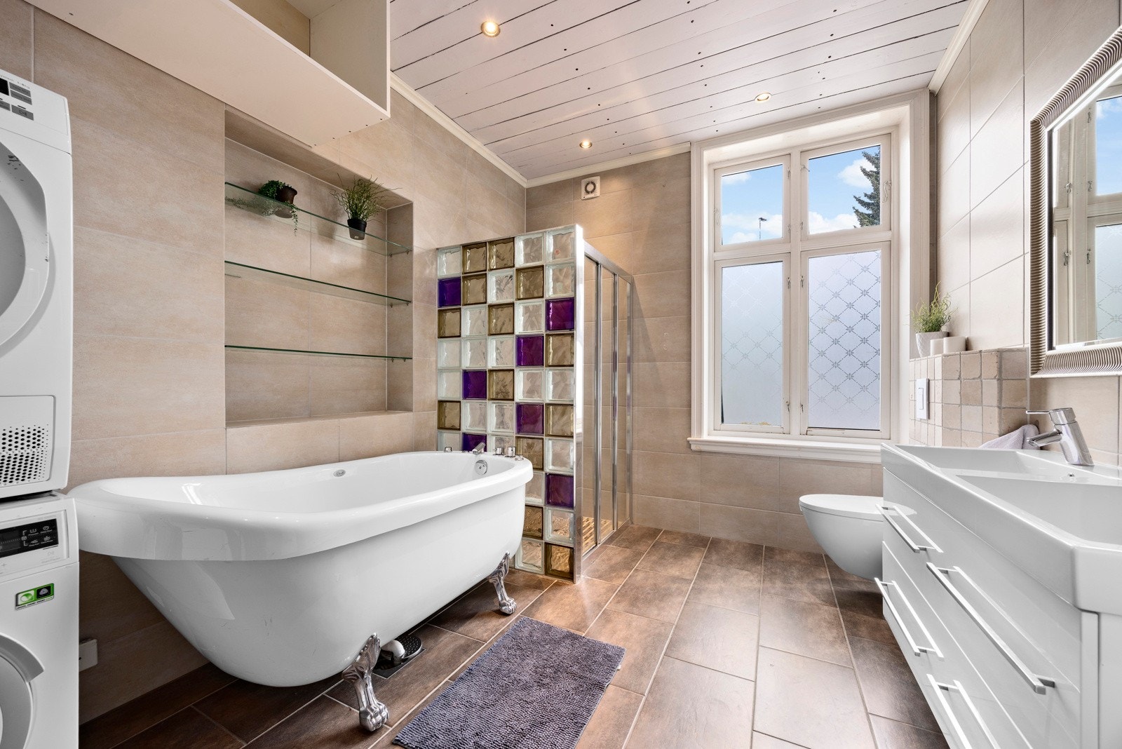 Badet er utstyrt med vegghengt toalett, dusjnisje, badekar, dobbel servant og opplegg for vaskemaskin. Badet ble oppgradert i 2015. Galleribilde