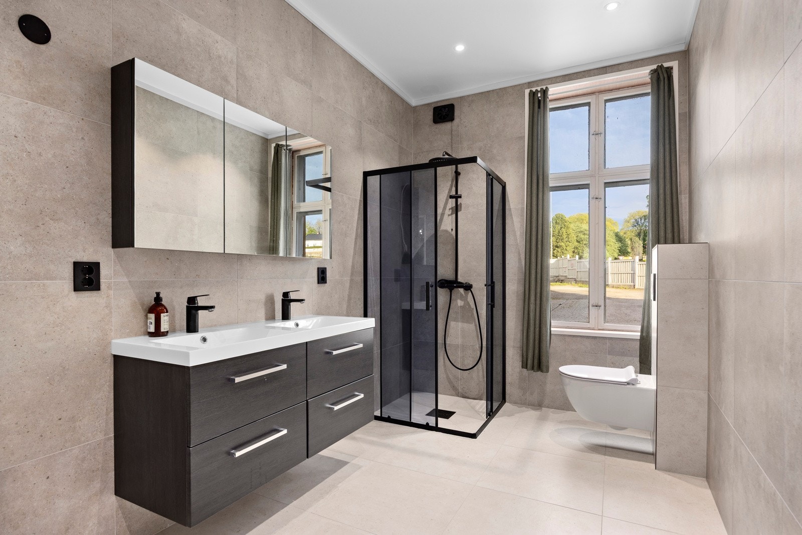 Badet er nytt fra 2025 og fremstår som moderne og lekkert. Badet er utstyrt med vegghengt toalett, dusjnisje, servant og opplegg for vaskemaskin. Galleribilde