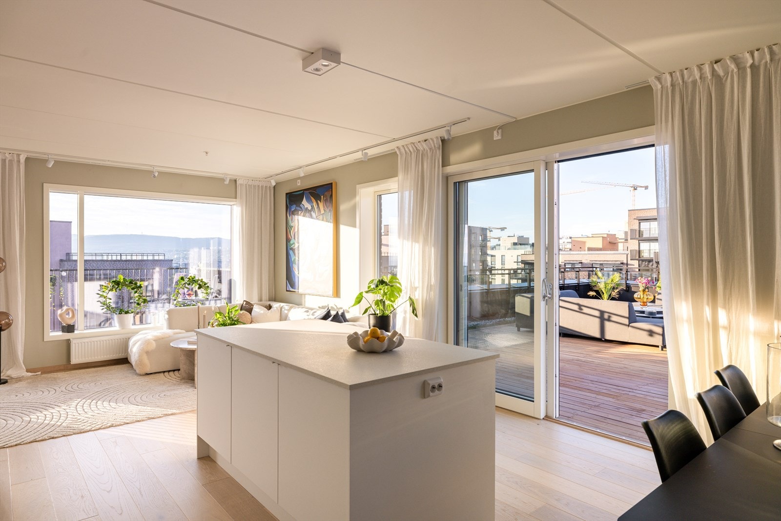 Leiligheten bader i lys hele dagen, med store vindusflater som slipper solen inn fra flere kanter. Galleribilde