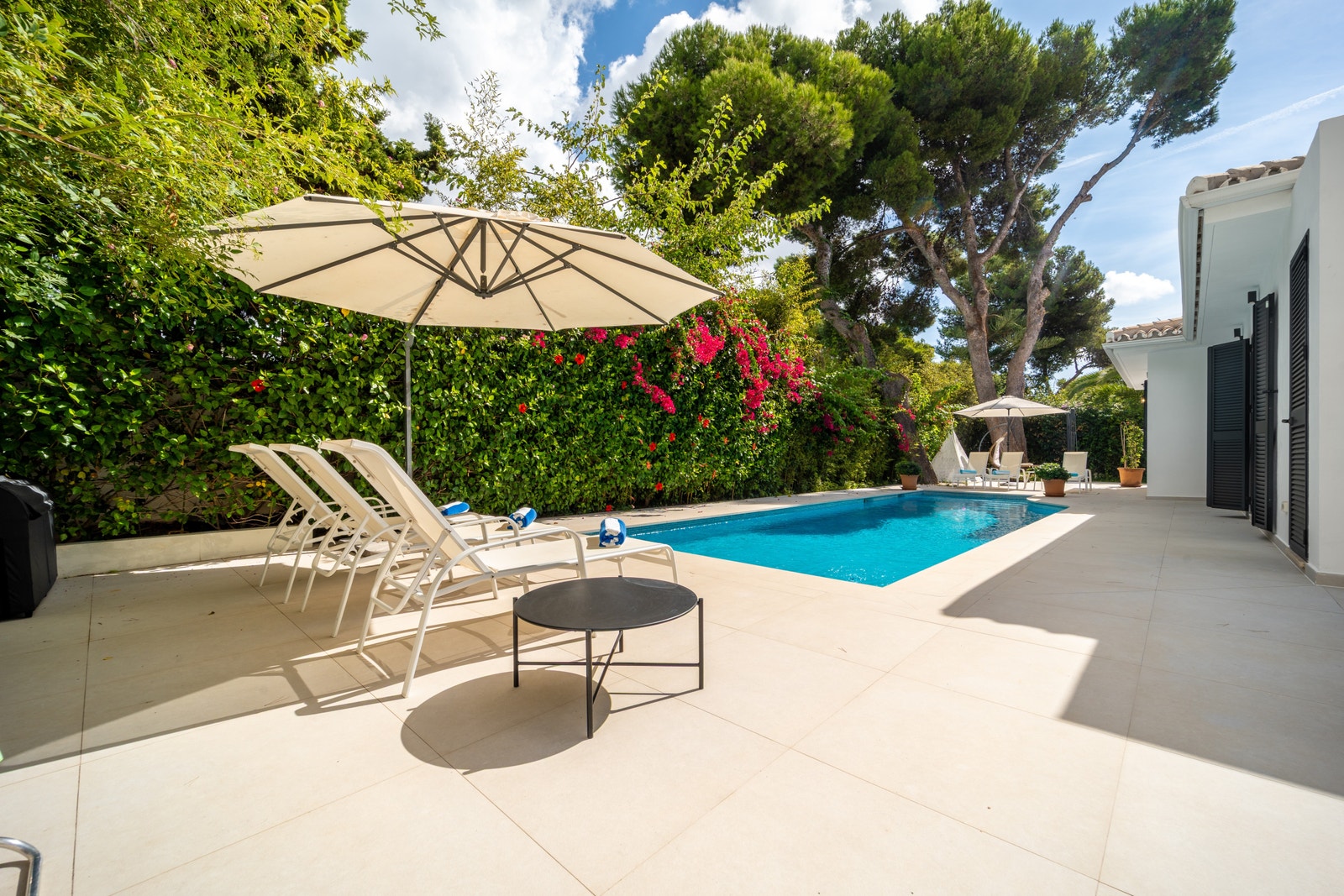 Slapp av i din fredelige oase, hvor solsenger og en stilfull uteplass ligger blant frodig grønt og levende, kaskadeformede bougainvillea. Nyt rolige øyeblikk i hjertet av eksklusive Los Monteros, bare noen minutter fra Marbellas berømte strender og attrak Galleribilde