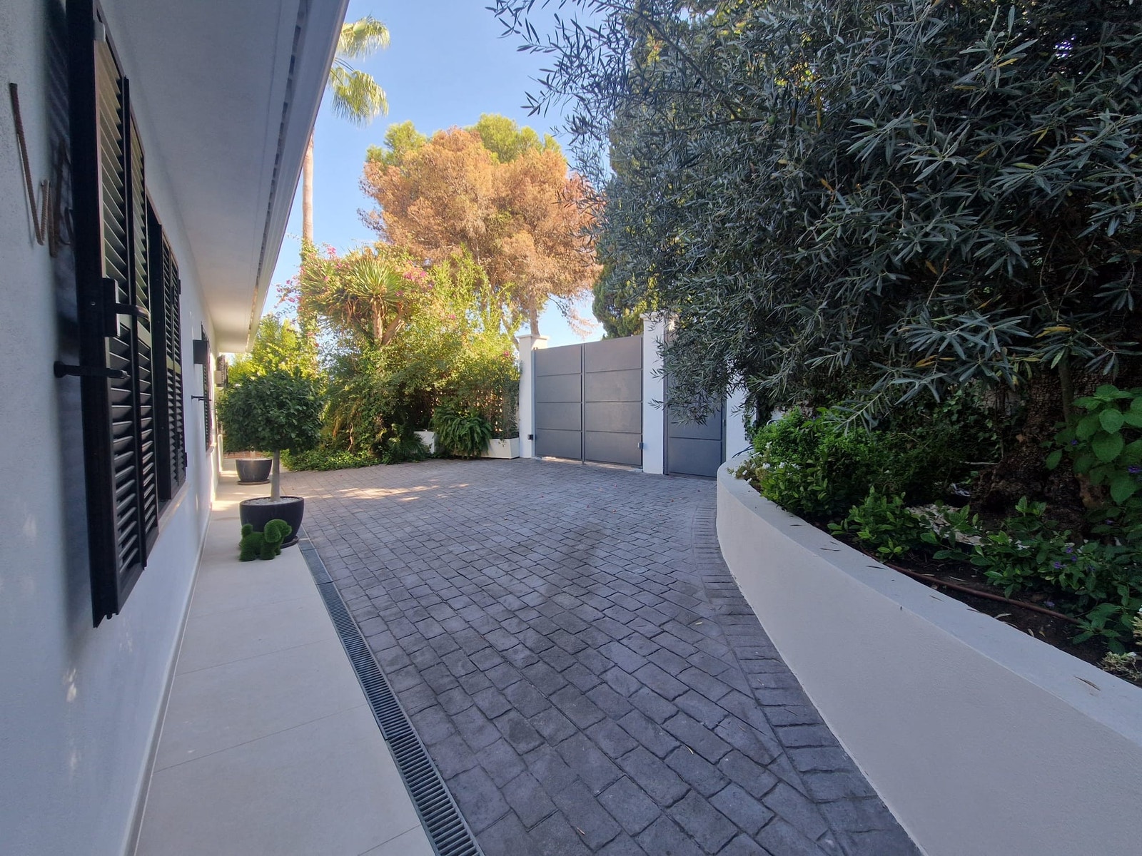 En sikker automatisk garasjeport med en praktisk sideinngang gir direkte tilgang til Casa Salma fra en fredelig blindvei. Den rolige gaten tilbyr rikelig med parkeringsplasser for deg og dine gjester, noe som sikrer enkel ankomst og komfort i hverdagen. Galleribilde