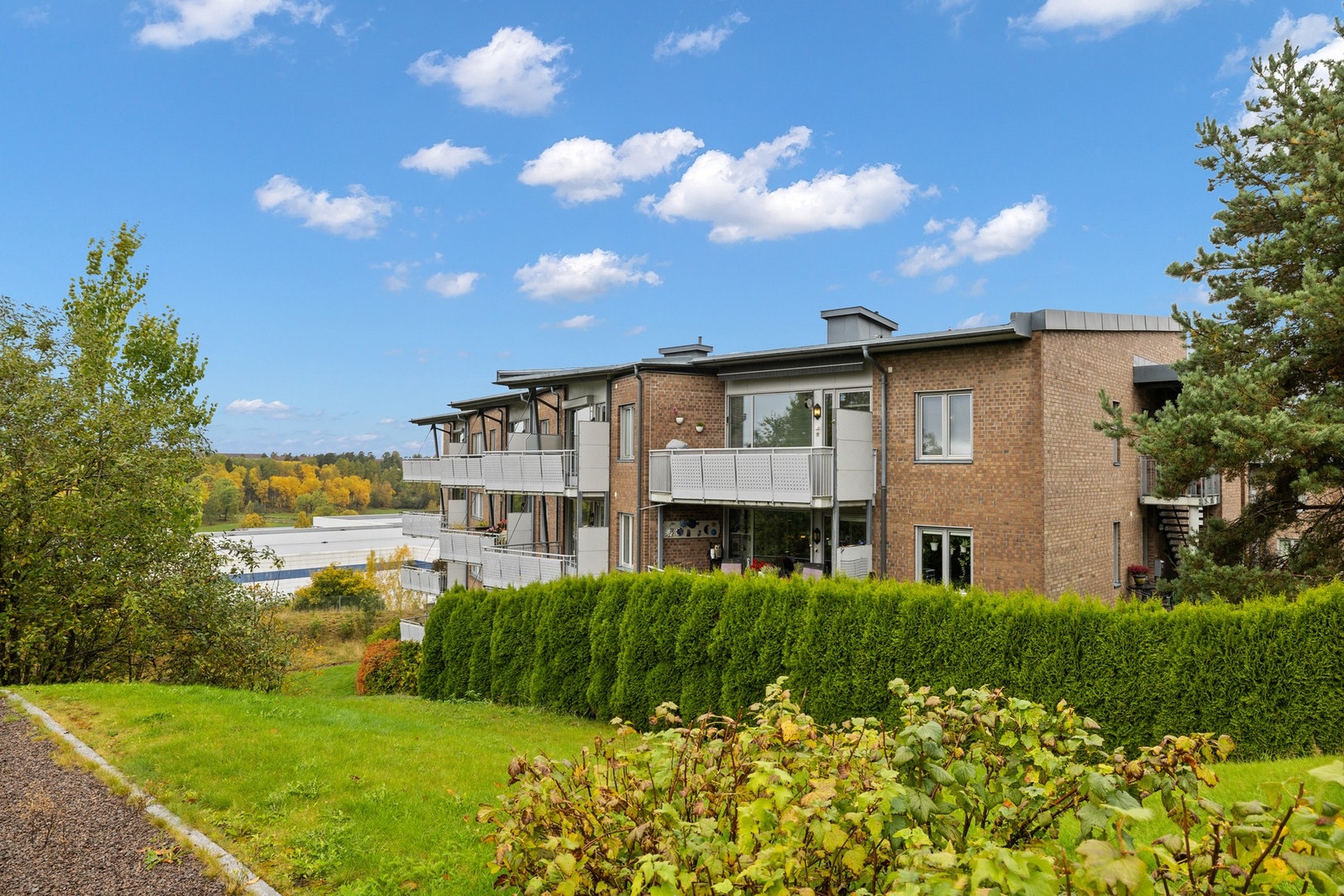 Eiendommen har romslige fellesarealer som er pent opparbeidet med asfalterte adkomstveier og parkeringsplasser, gressplen, beplantning og trær. Galleribilde