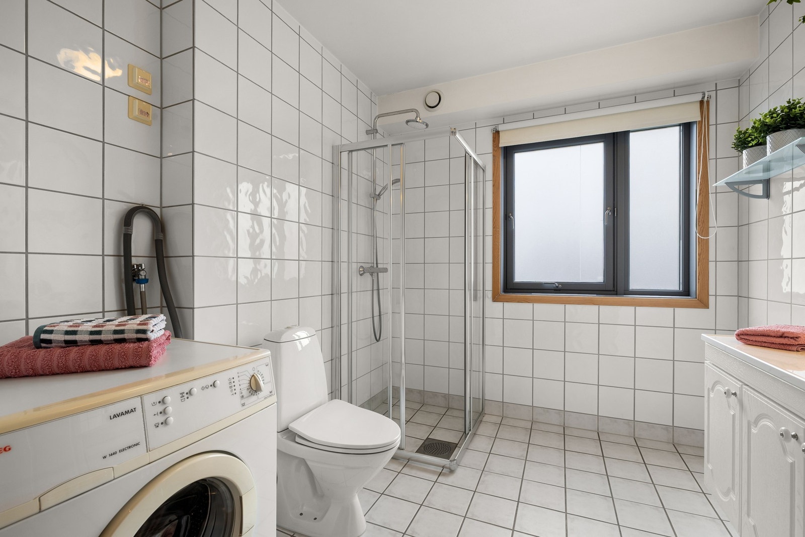 Rommet er innredet med servant med underskap, speil og belysning, samt klosett og dusjnisje med veggmonterte dusjvegger og termostatbatteri. Galleribilde