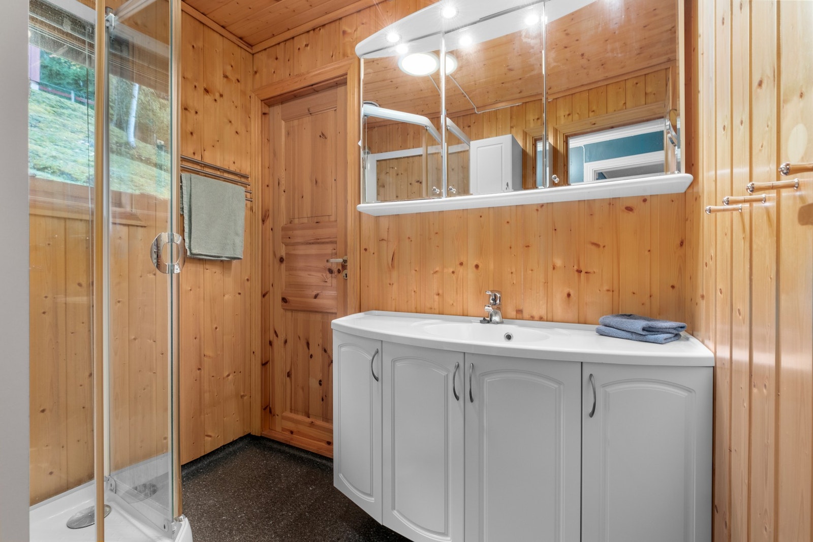 Belegg på gulv og panel på vegger med varme i gulv. Baderommet er utstyrt med servant, servantskap, naturlig avtrekk og dusjkabinett. Galleribilde