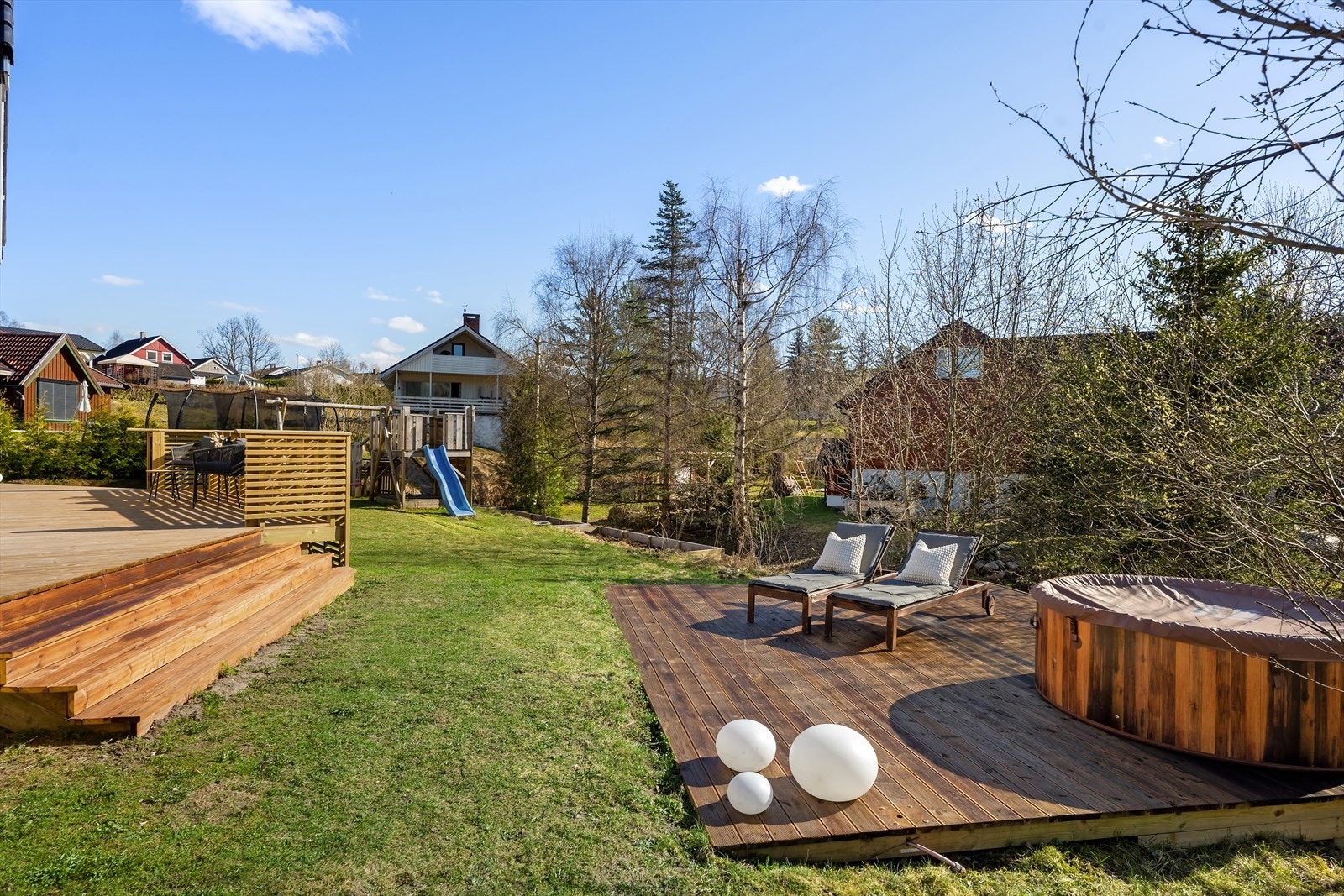 Pent opparbeidet uteområdet med flere soner. Her er det stor plen, lekestativ, terrasse, solplatting og plantekasser. ( Boblebad medfølger ikke). Galleribilde