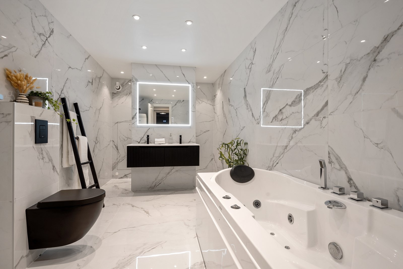 Boligen har 3 bad. Hovedbadet er lekkert flislagt med lyse marmorerte fliser og mørke detaljer på innredningen. Galleribilde