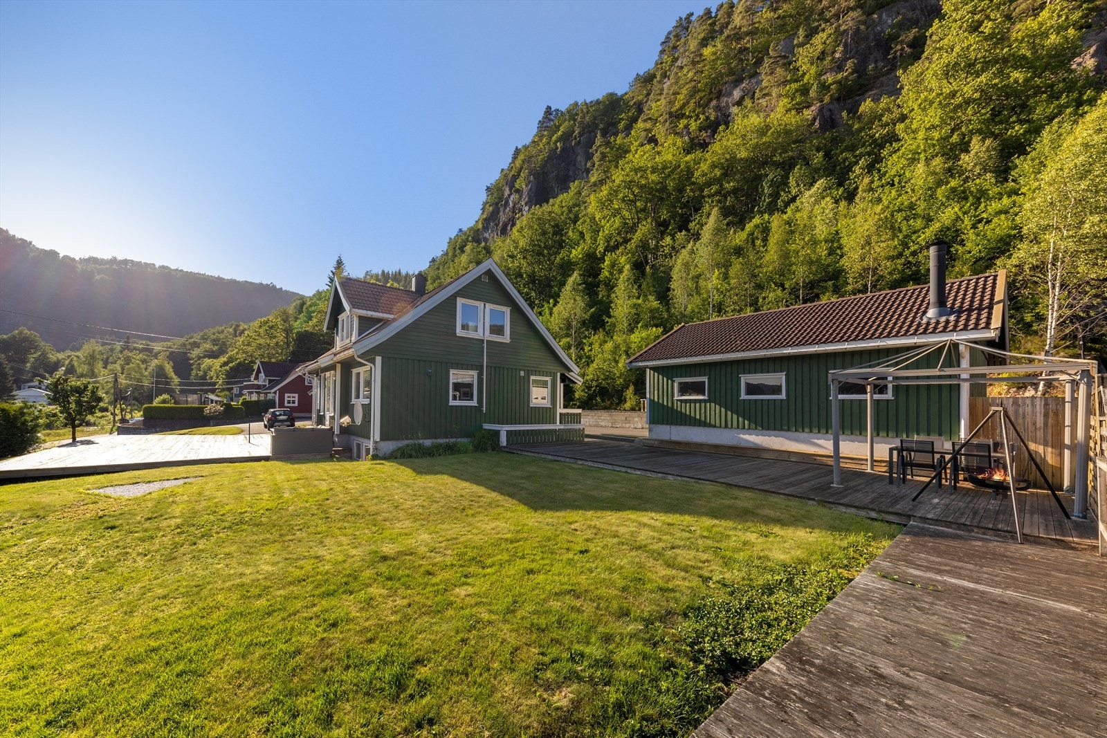 Flatt område med plen og terrasser. Galleribilde