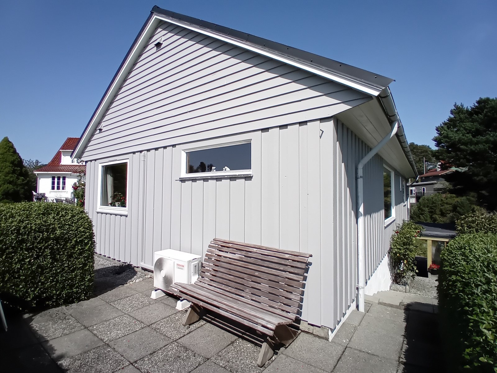 Tomten er flott opparbeidet med romslige uteplasser, hekk og prydbusker Galleribilde