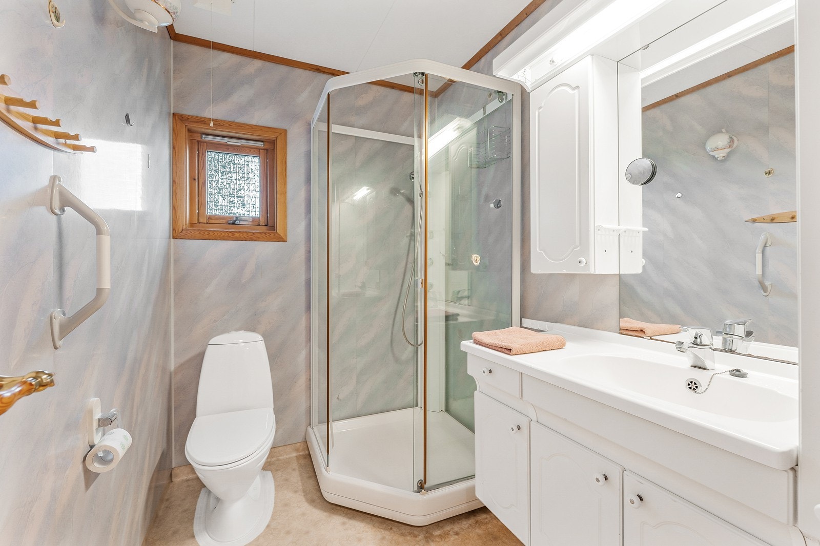 Badet er av god størrelse og innredet baderomsinnredning med heldekkende servant og ettgreps blandebatteri, gulvstående toalett samt dusjkabinett Galleribilde