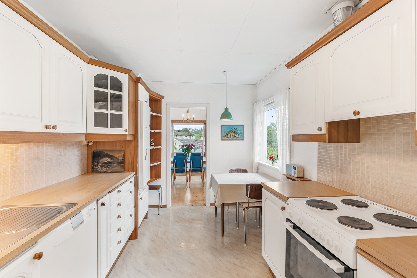 Kjøkkenet har profilerte, malte fronter og benkeplate i laminat med nedsenket vask og ettgreps blandebatteri Galleribilde