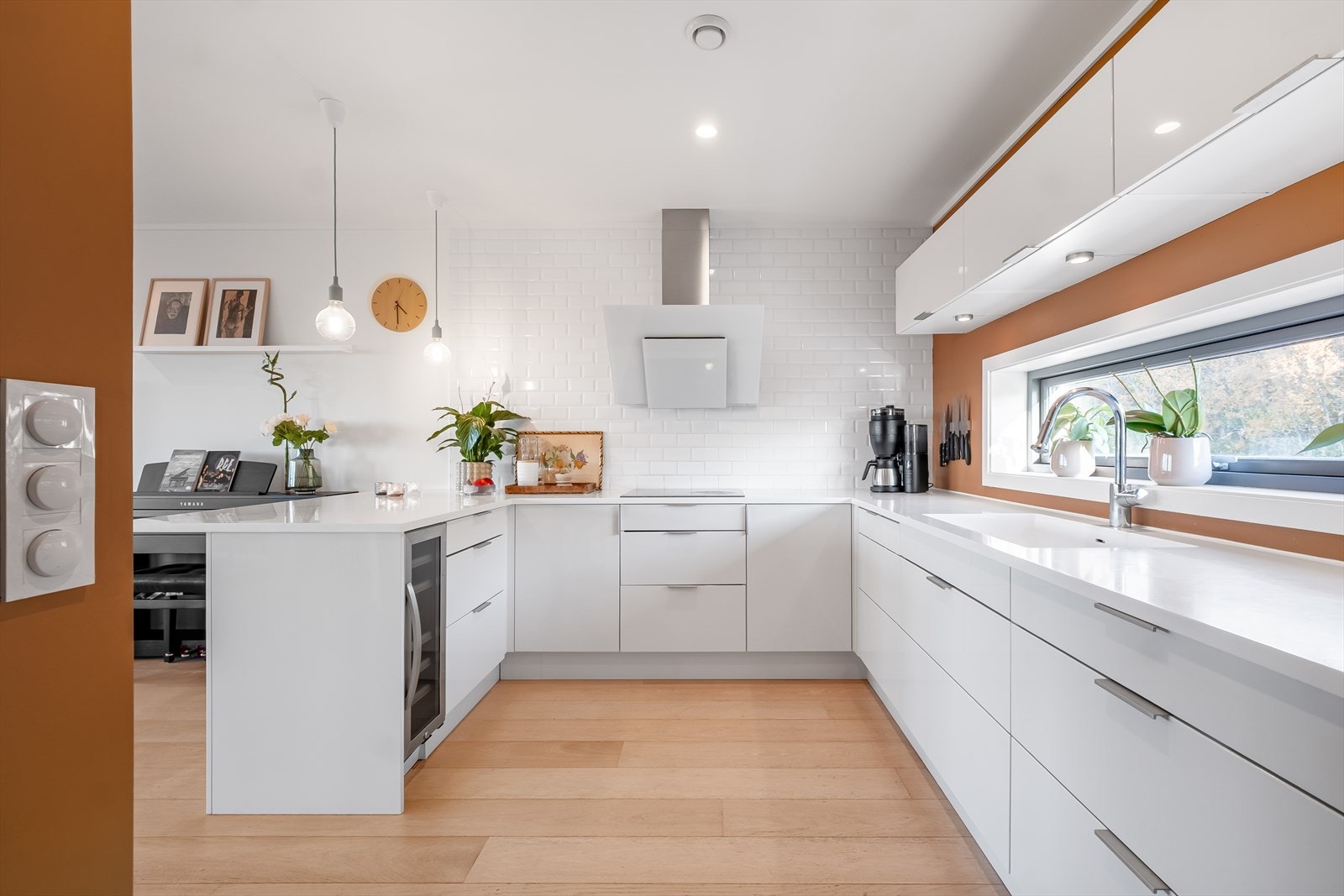 Lys og moderne kjøkkeninnredning som har godt med skap- og benkeplass. Galleribilde