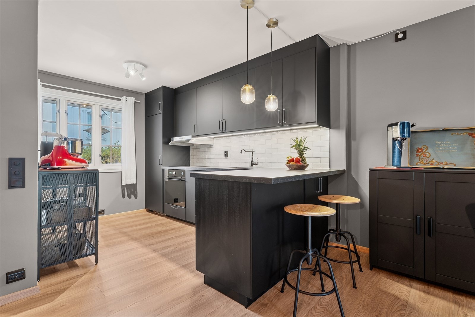 Kjøkkenet har en stilren og moderne innredning i mørk utførelse. Galleribilde