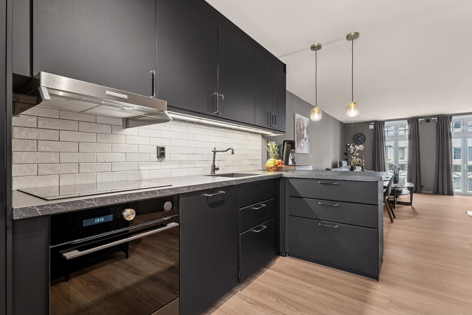 Benkeplaten er utstyrt med vaskekum og kjøkkenkran, og det er praktisk belysning montert under overskapene. Galleribilde