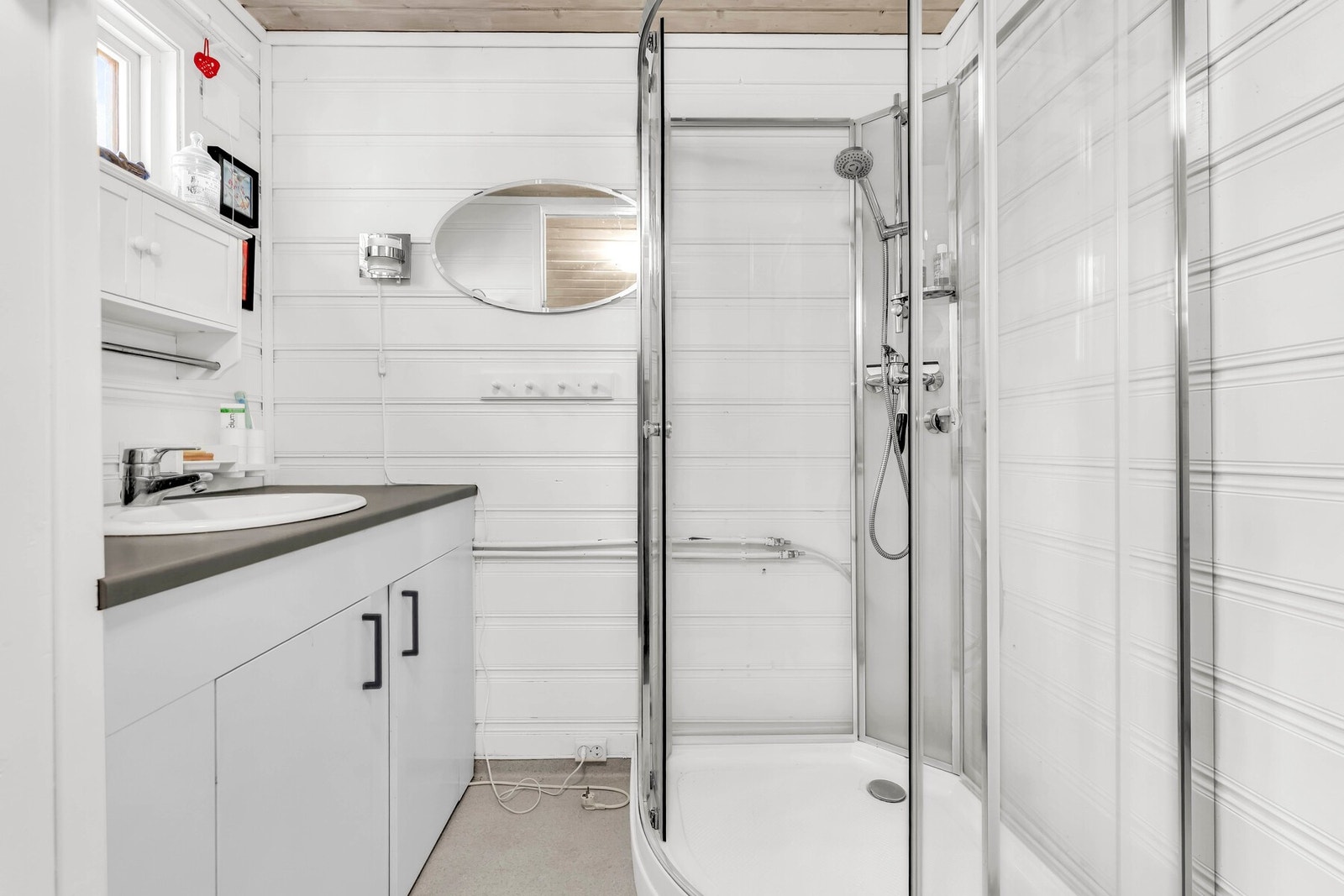 Badet har dusjkabinett, innredning med speil og snurredo. Galleribilde