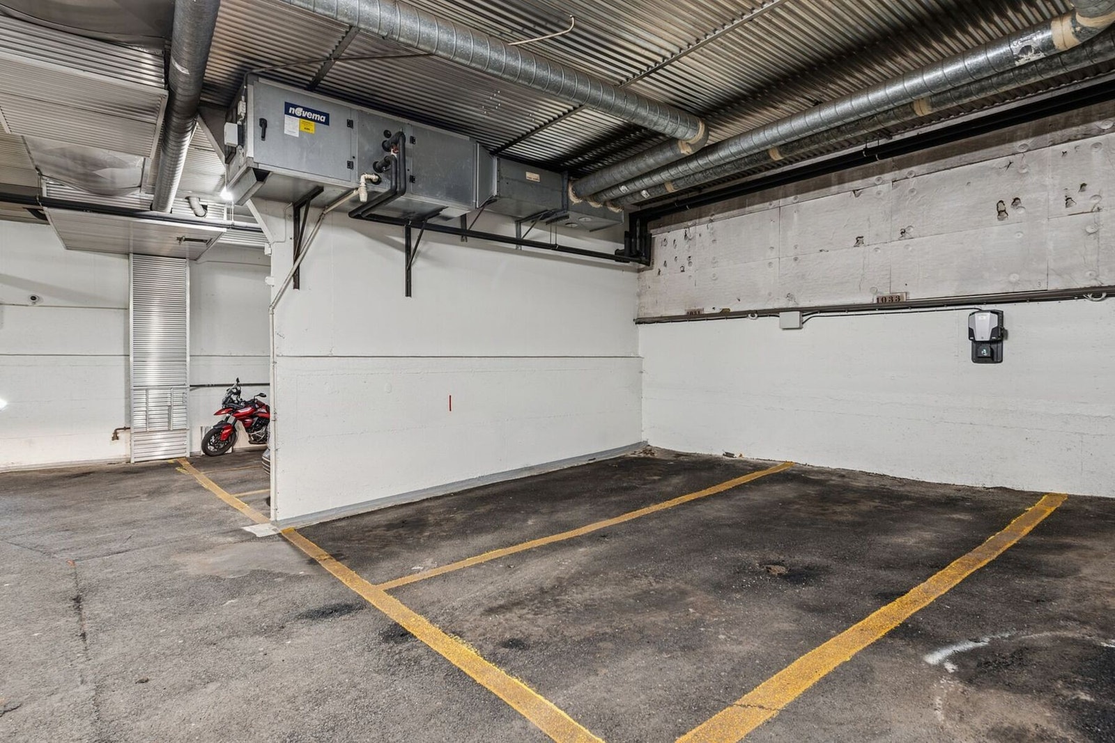 Med boligen følger en egen garasjeplass med elbillader, i felles lukket garasjeanlegg under bygningen. Plassen som følger er nr. 1033 - i midten. Galleribilde