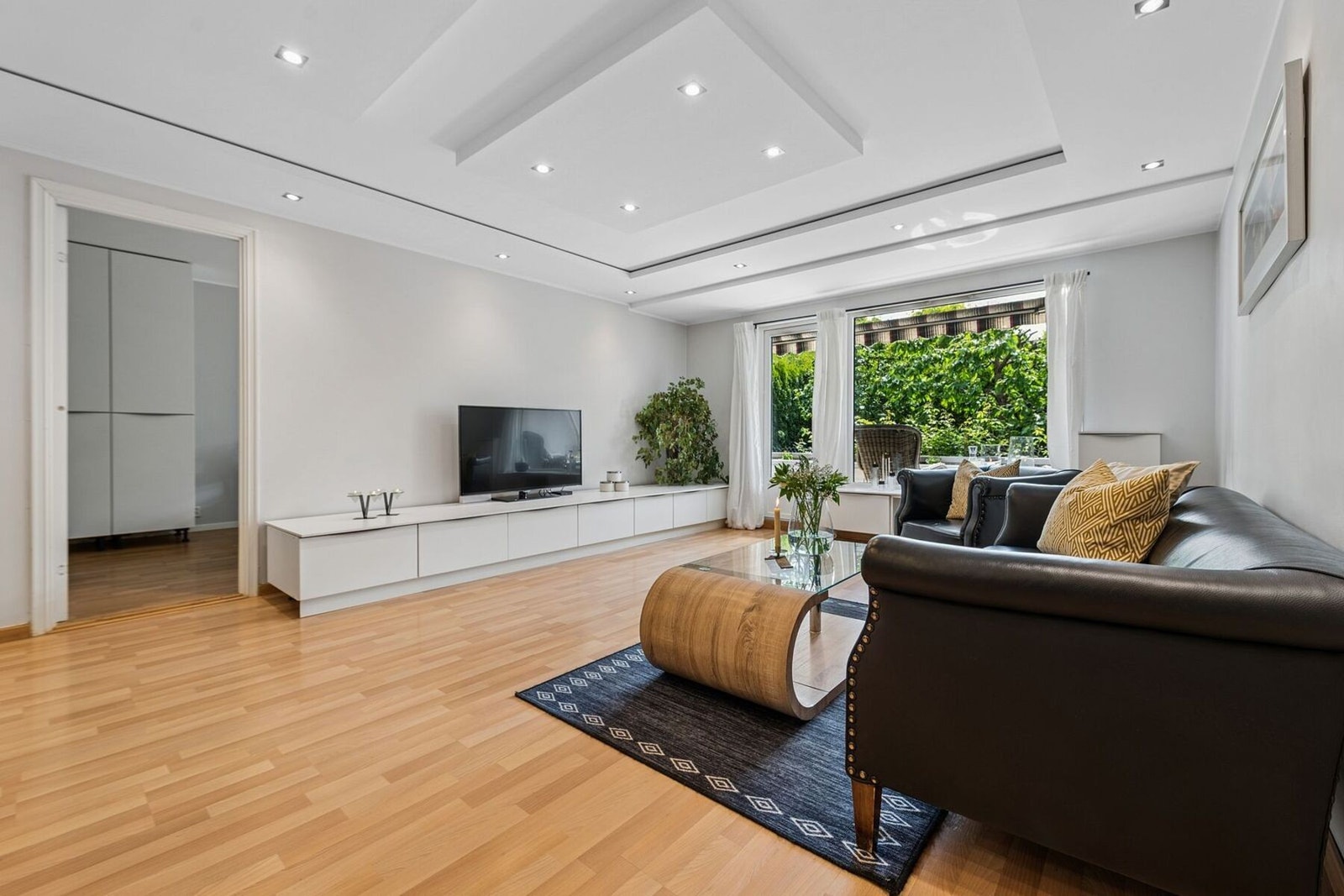 Stuen er innbydende og har utgang til en herlig, solrik terrasse på 12 kvm og usjenert, frodig hage. Nedsenkede partier med integrerte LED-stemningslys og downlights i himling. Galleribilde