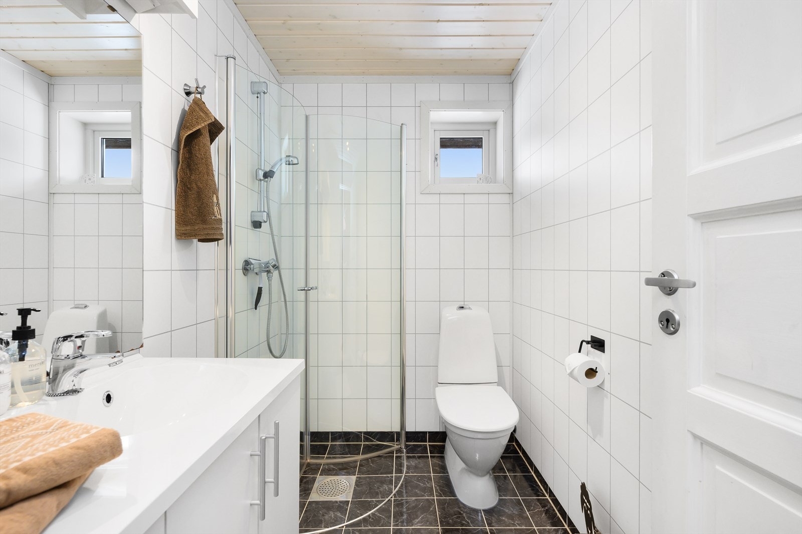 Badet har fliser på gulv og baderomsplater på vegg. Galleribilde