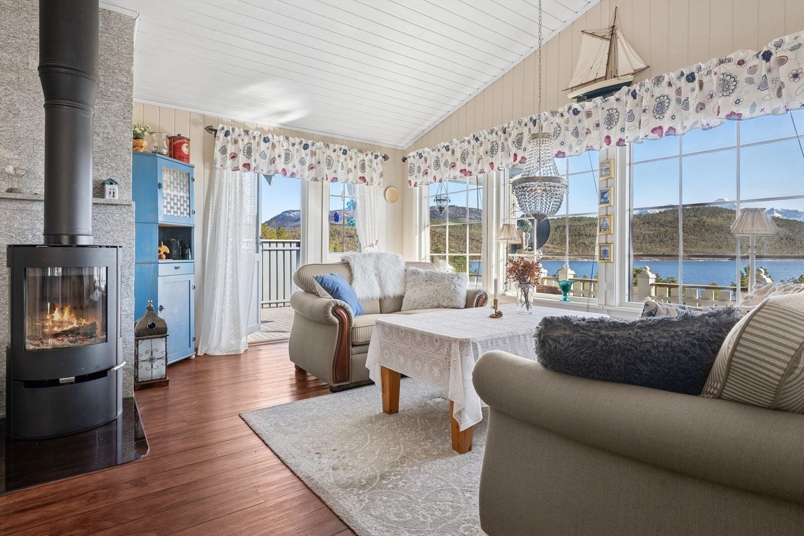 Meget tiltalende hytte i lyse farger og masse vinduer, som passer godt for en hytte så nærme sjøen. Galleribilde