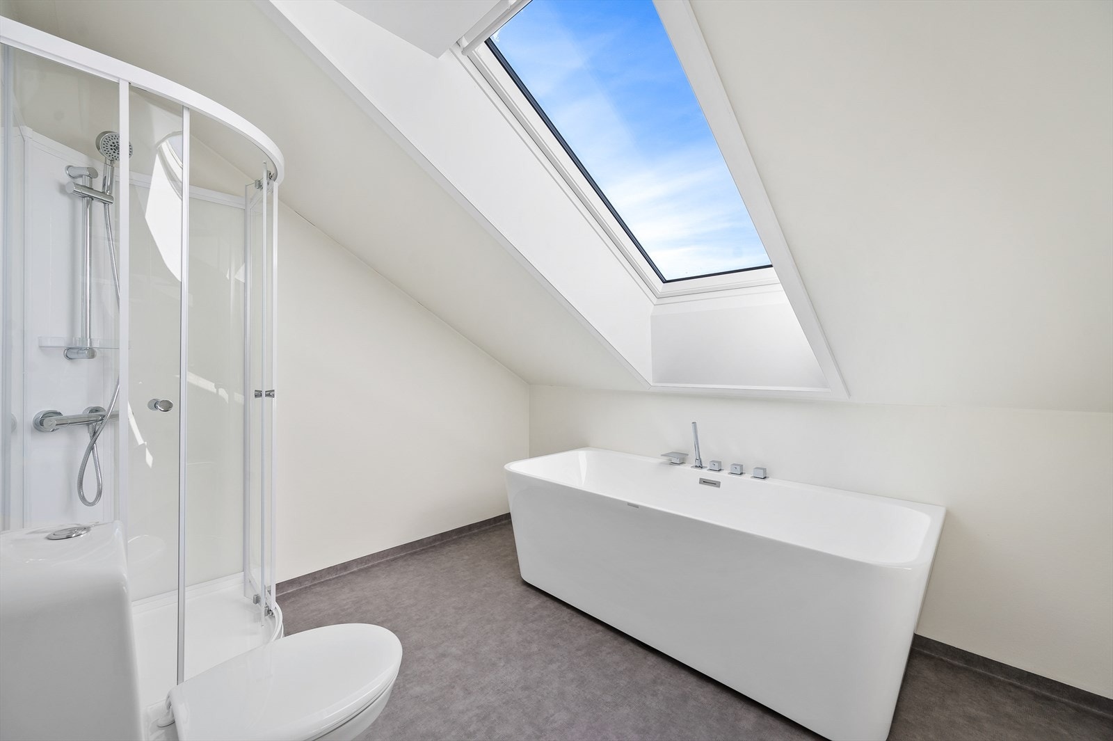 Bad i loftsetasjen med dusjkabinett, badekar og toalett. Galleribilde