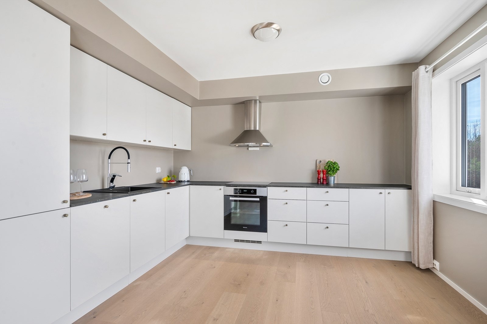 Pent kjøkken med lyse fronter, integrerte hvitevarer, god skap- og benkplass! Galleribilde