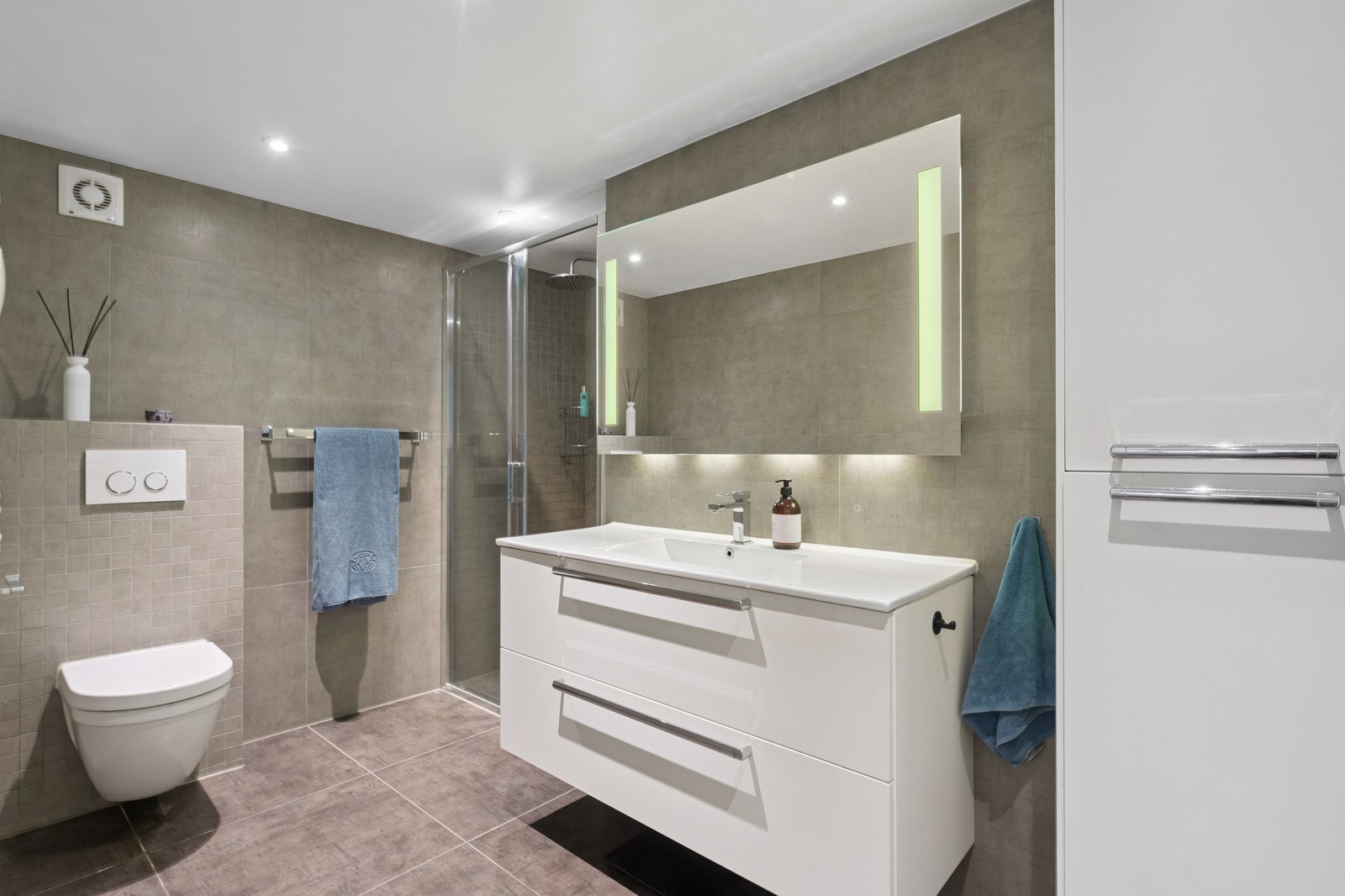 Bad med dusj, servant, baderomsinnredning og wc i underetasjen. Galleribilde